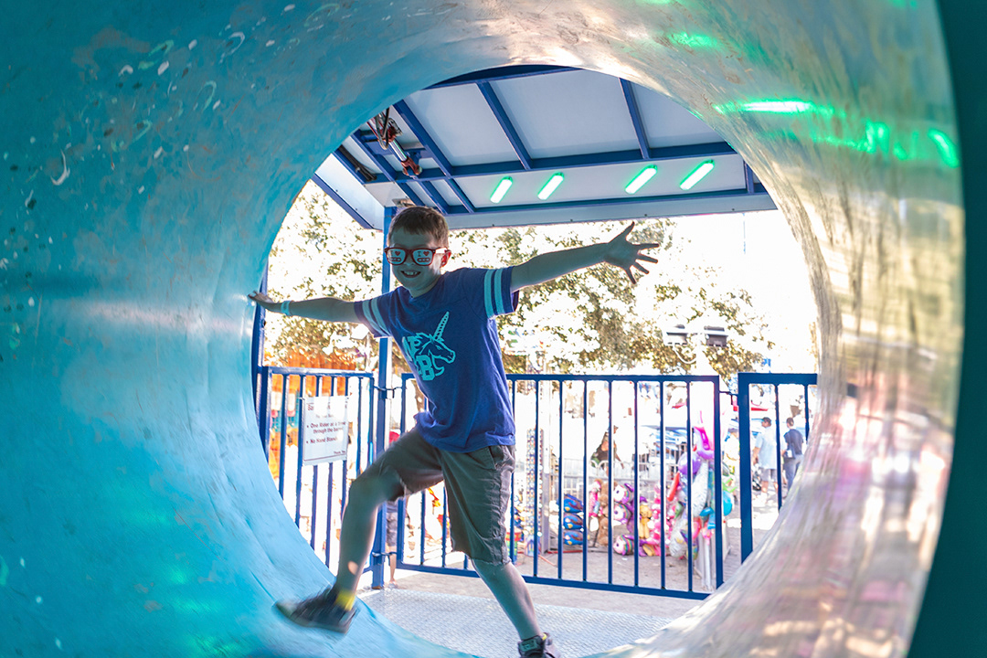 A boy walks through a spinning cylinder in one of the carnival attractions at the Comal County Fair on Sept. 24, 2024. BLAINE YOUNG | Herald-Zeitung
