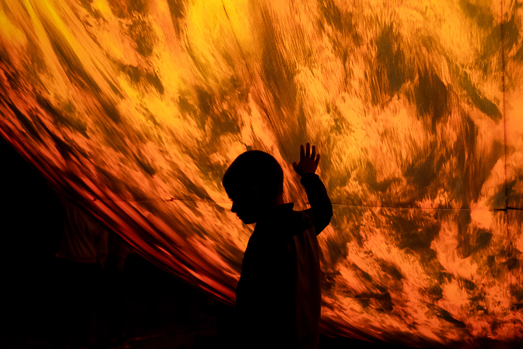 A boy next to a model of the sun during the Festival of the Planets in Brno on Aug. 8, 2023.
