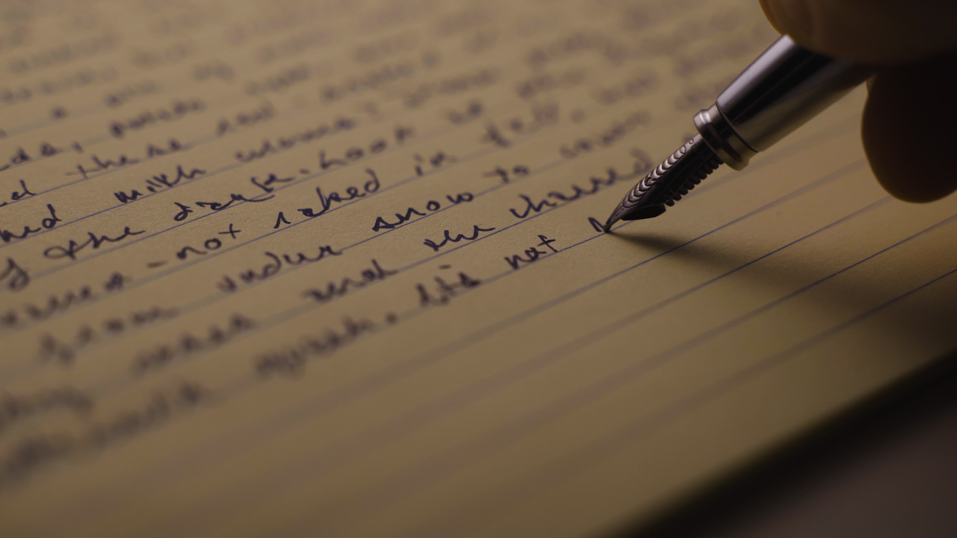 Close-up shot of a fountain pen writing in cursive on a yellow legal pad, bathed in cinematic warm light, creating a thoughtful, nostalgic mood.