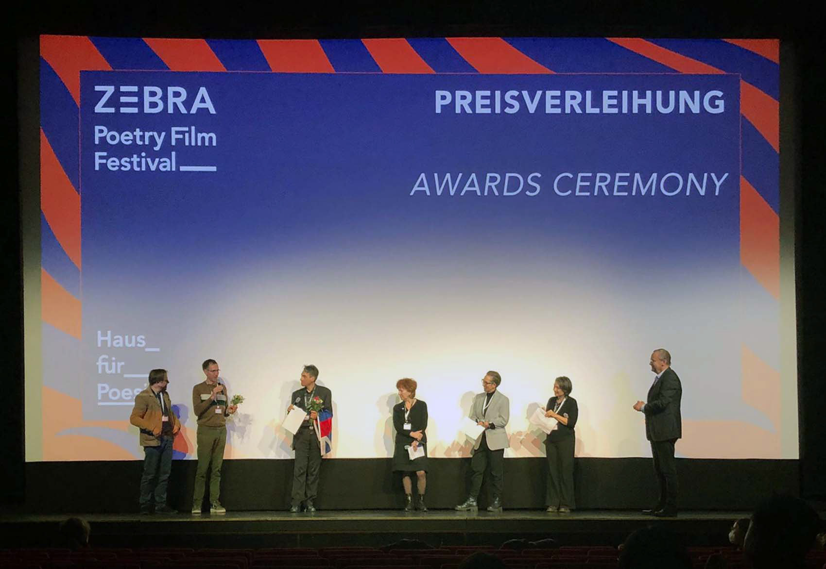 Receiving the honourable mention. From left to right: Jan Peeters, Paul Bogaert, artistic director Thomas Zandegiacomo Del Bel, jury members Doris Hepp (DE, commissioning editor and producer for a.o. ZDF and Arte), Hinemoana Baker (NZ, writer and performer), Delphine Maury (FR, editor and producer) and moderator Knut Elstermann.