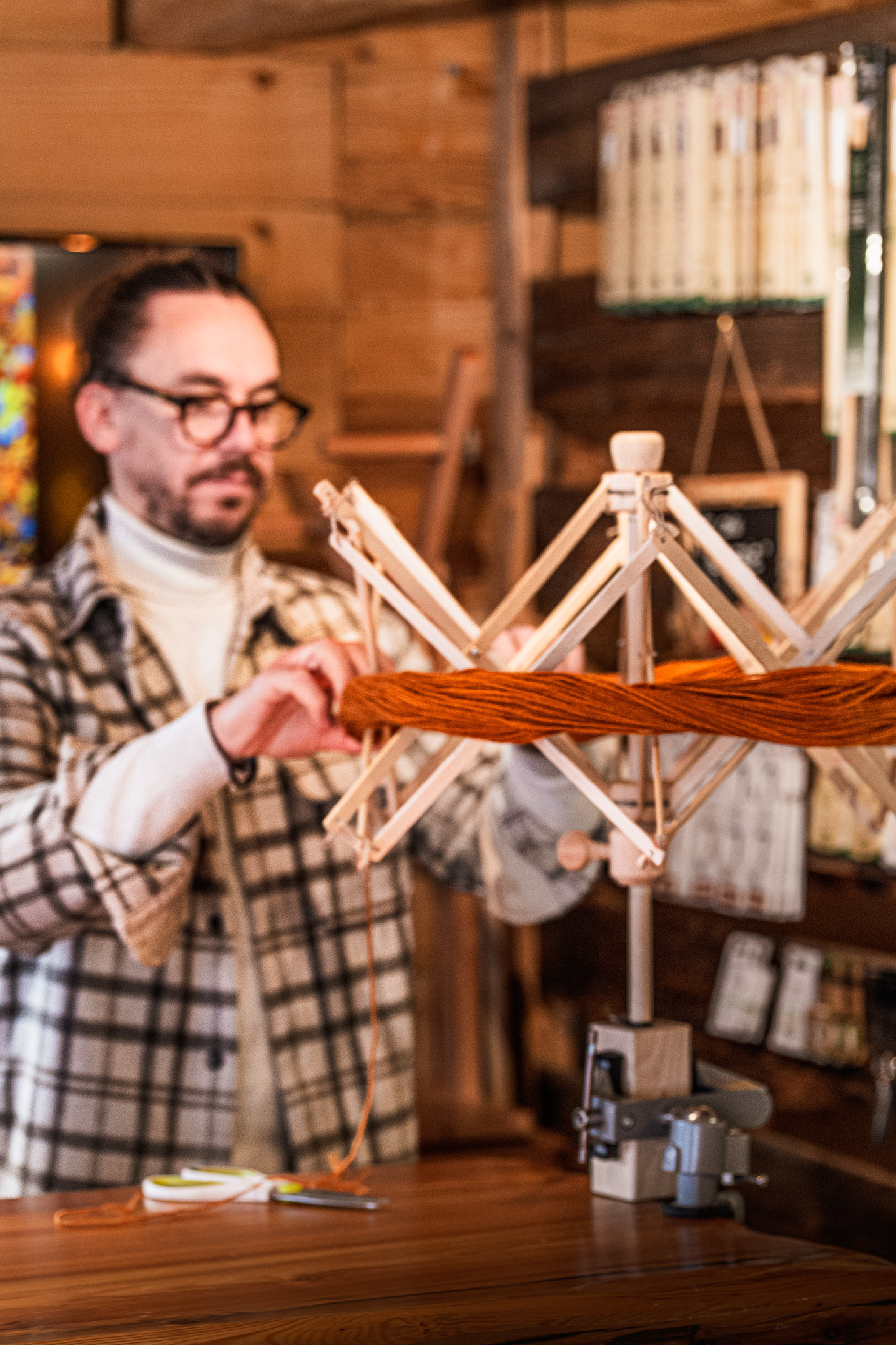 Mise en écheveau de la laine sur un dévidoir en bois par l'artisan teinturier à Valloire