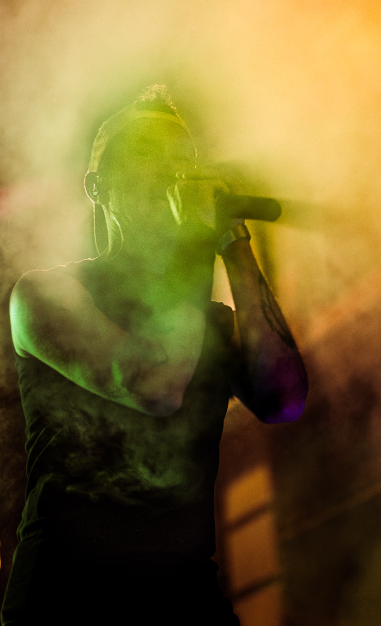 Chanteur de Pogosticks sous un projecteur vert et la fumée pendant le concert à La Chistera