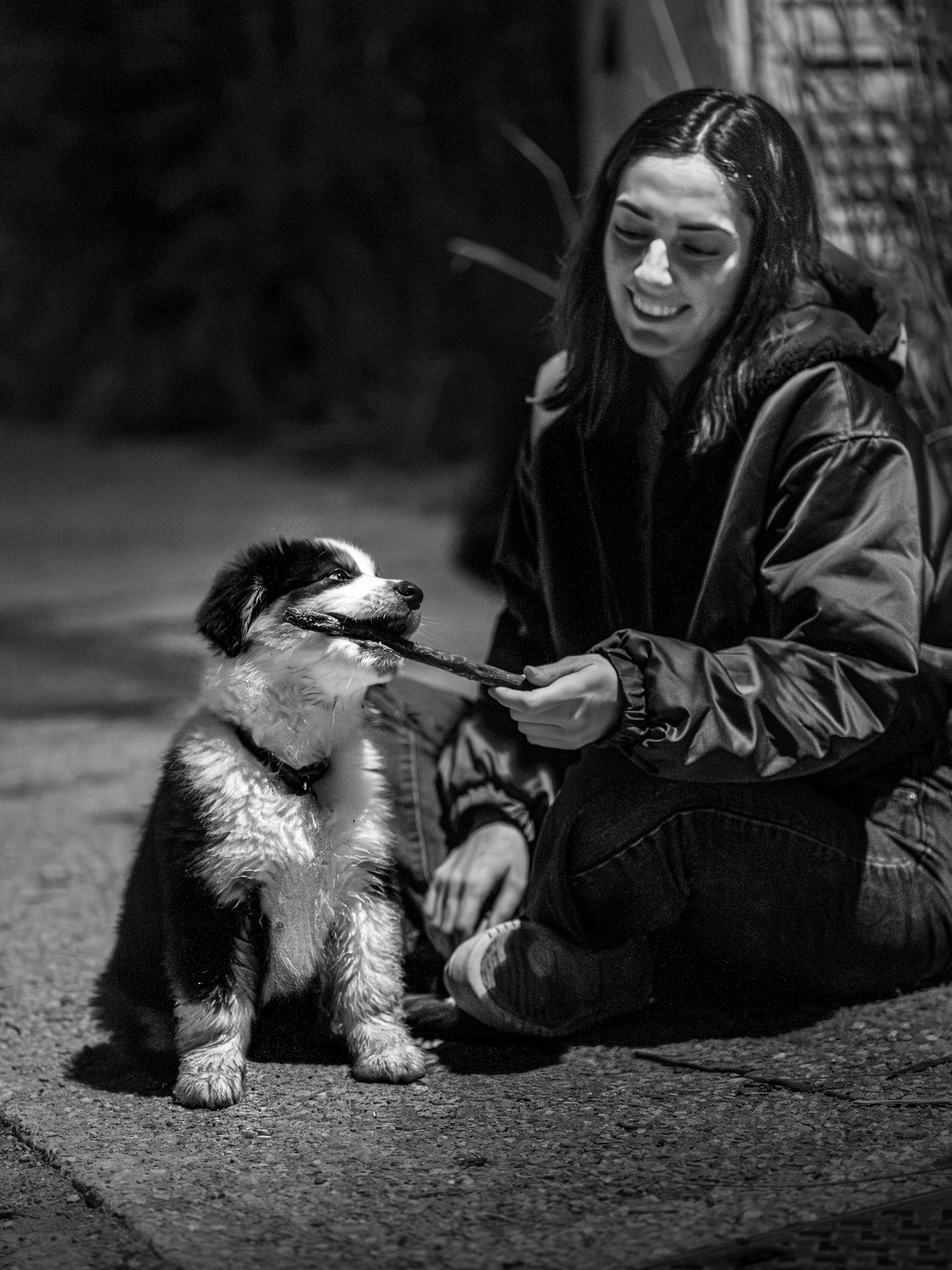 Jeu et partage entre Emma et son chiot Baksy sous l'éclairage urbain