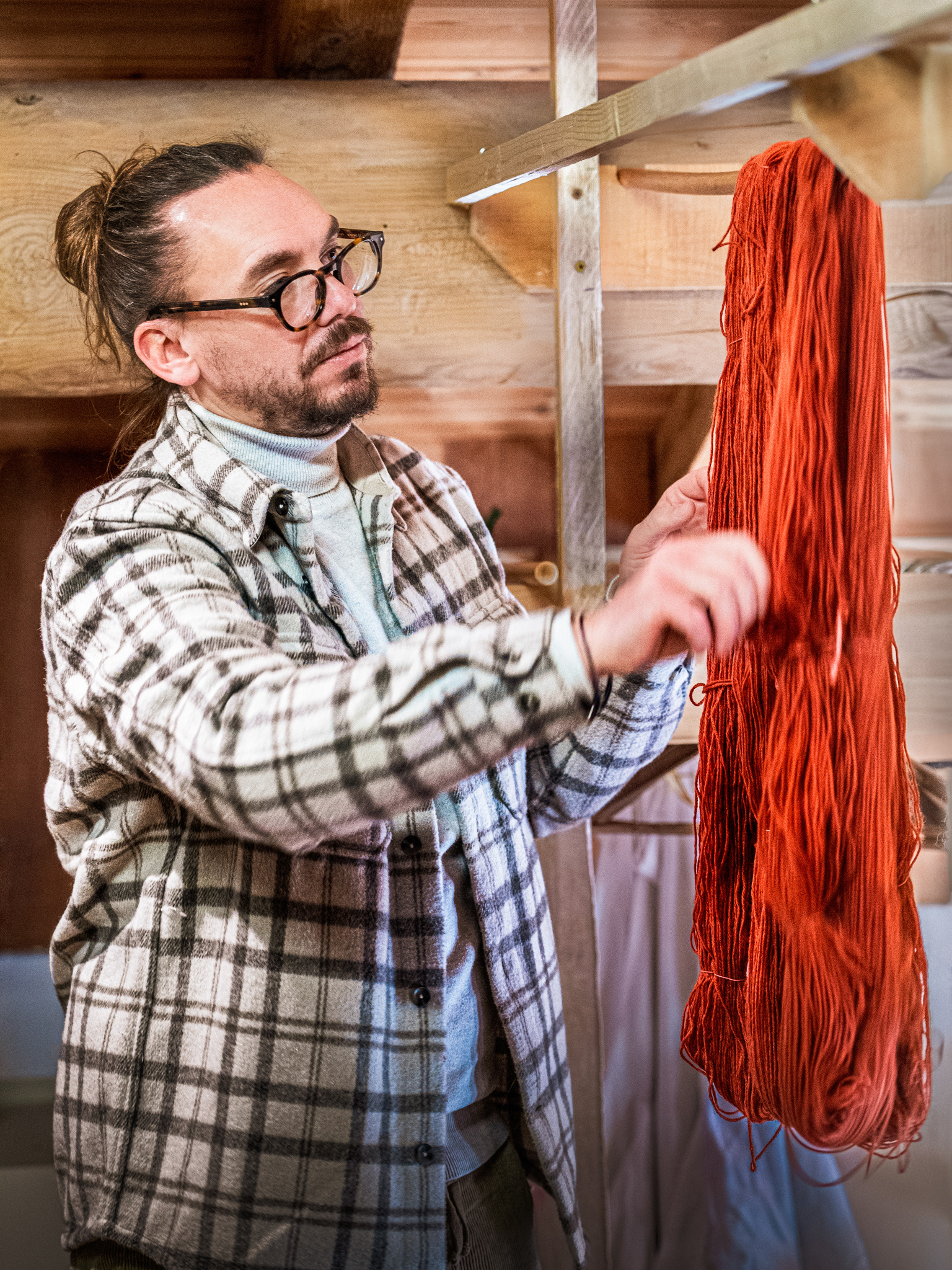 Yannick de l'Atelier 1720 observant la couleur d'un écheveau de laine végétale à Valloire