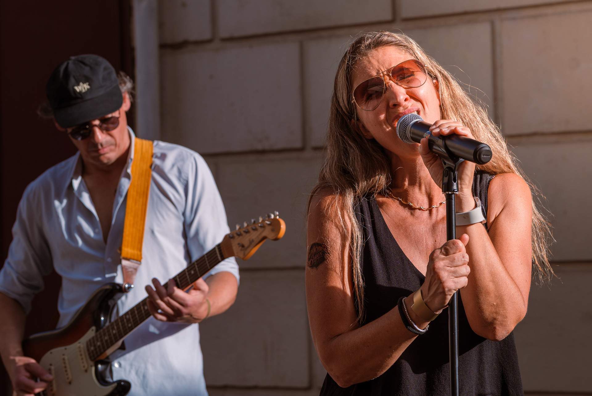Prestation scénique de la chanteuse et du guitariste en concert extérieur