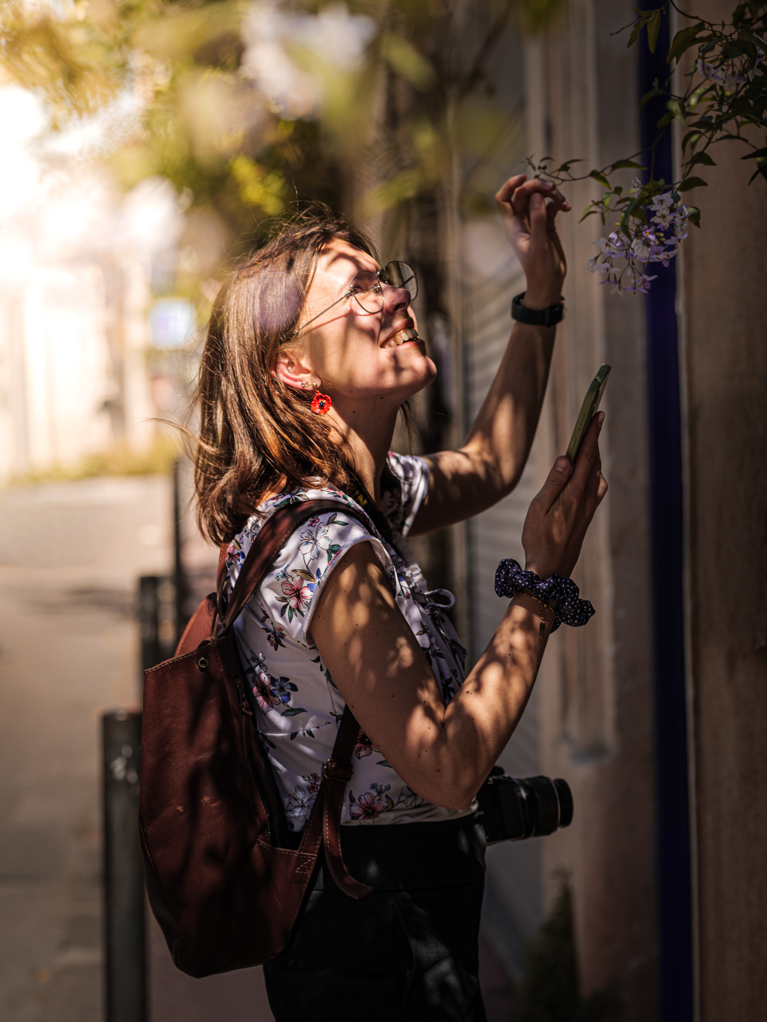 Une intervenante du CAUE qui observe de près une plante grimpante sur une façade