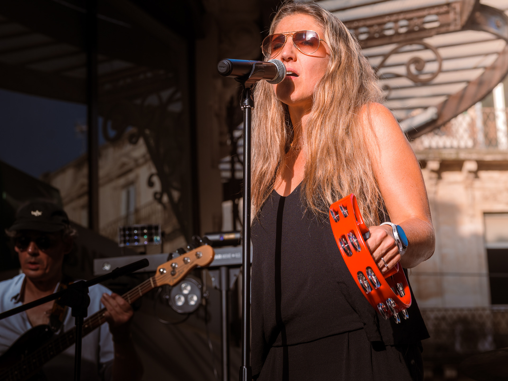Chanteuse au tambourin et bassiste en action sur la scène du concert