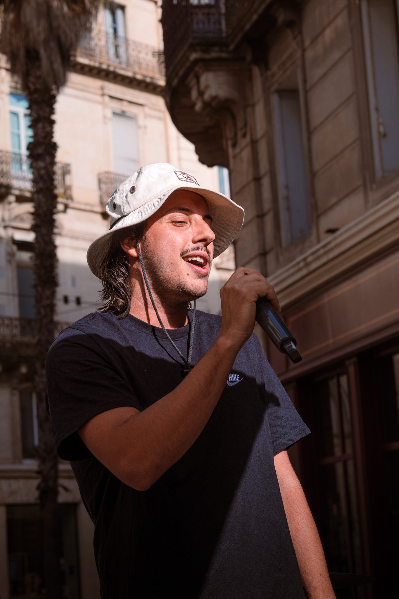 Jeune interprète au bob chantant au micro à Montpellier