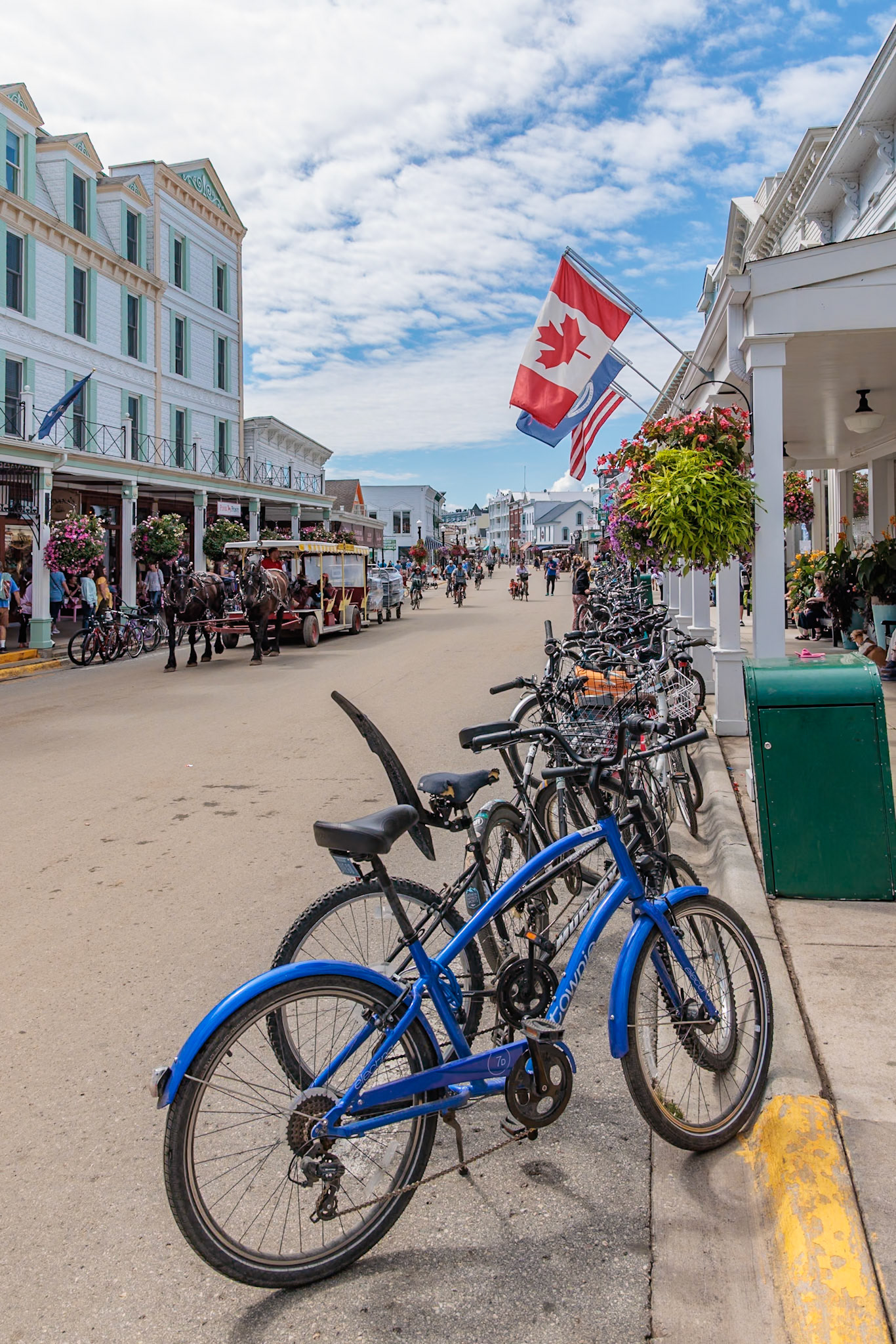 250821_087 Street lined with rental bicycles while their riders visit shops and restaurants on Mackinac Island, Michigan, USA
