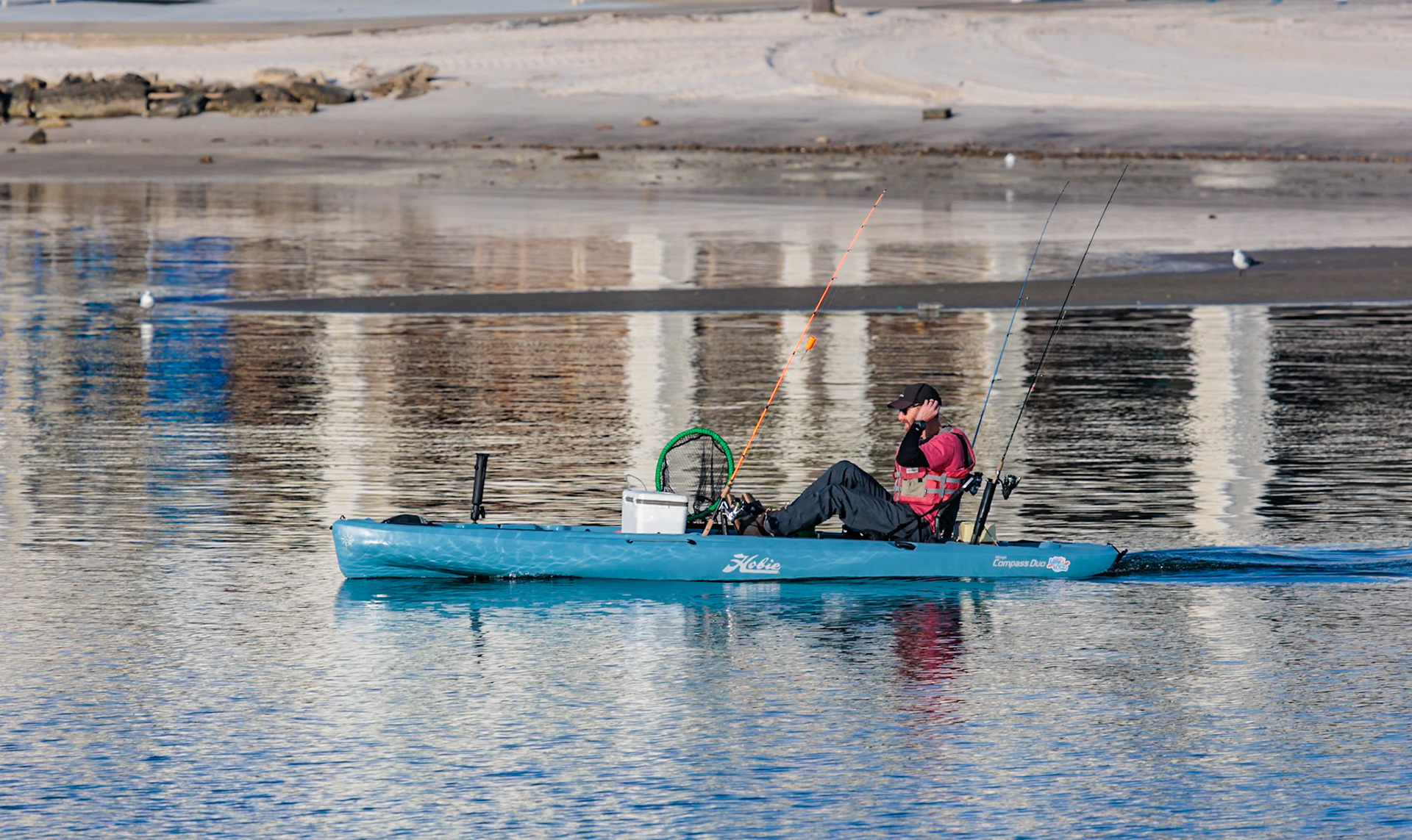 220114_124 Man in Hobie kayak heads into the Gulf of Mexico for fishing at Gulfport, Mississippi, USA