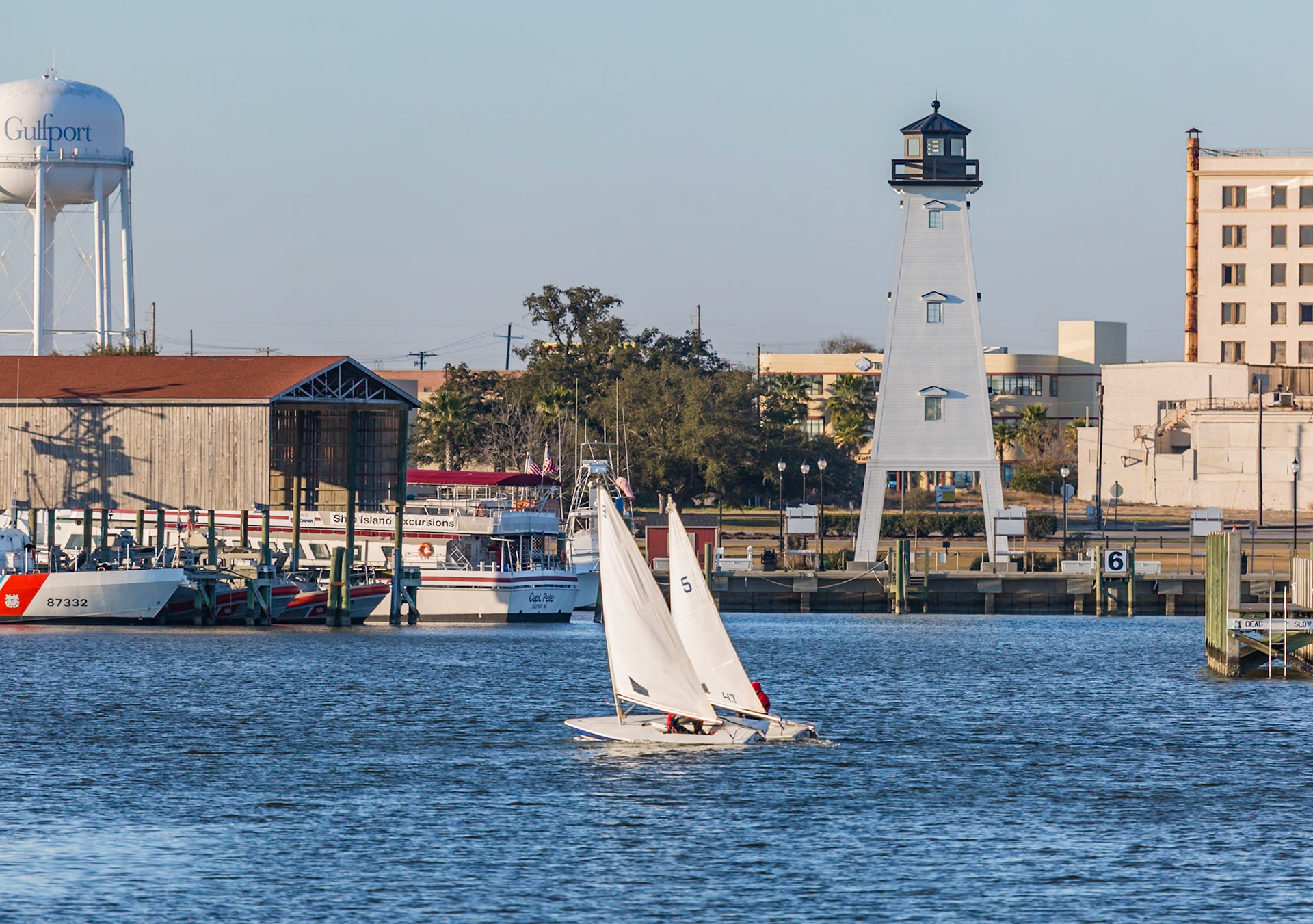 160123_158 Two male youth sailing on Laser sailboats in the Gulf of Mexico at Gufport Harbor in Gulfport, Mississippi