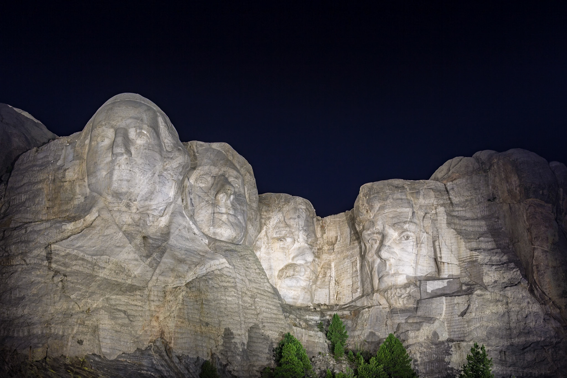180814_317 Carved granite busts of George Washington, Thomas Jefferson, Theodore "Teddy" Roosevelt and Abraham Lincoln framed by trees at Mount Rushmore National Monument near Keystone, South Dakota