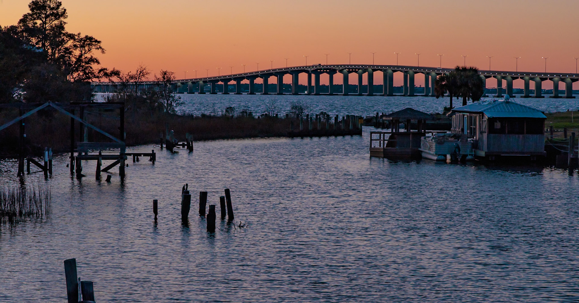 230125_234 Sun sets behind the Bay St. Louis bridge at Henderson Point in Pass Christian, Mississippi