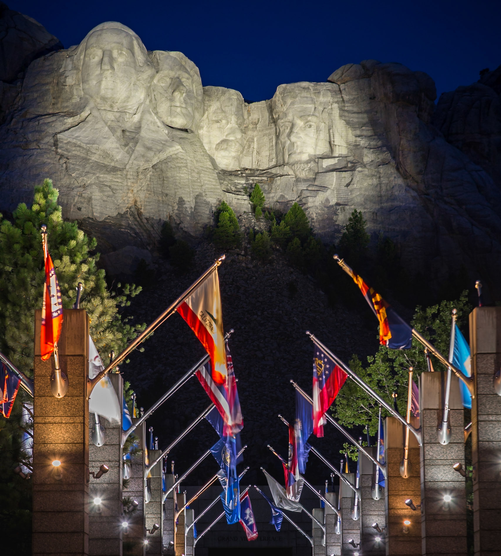 180814_303 Carved granite busts of George Washington, Thomas Jefferson, Theodore "Teddy" Roosevelt and Abraham Lincoln above the Avenue of Flags at the entrance to Mount Rushmore National Monument near Keystone, South Dakota