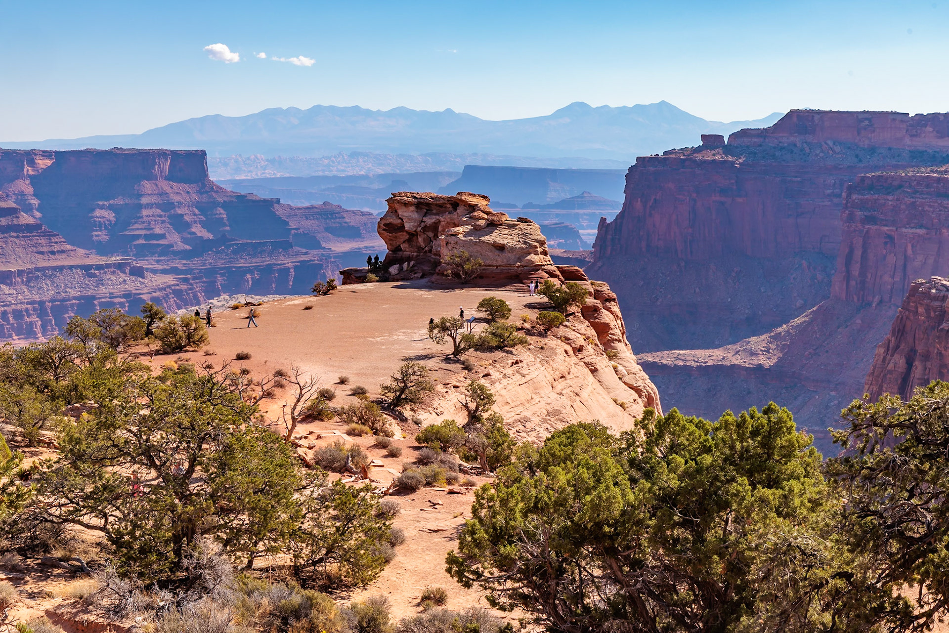 240928_012 Tourists walking on a butte along the Shafer Canyon Overlook at the Island in the Sky area of Canyonlands National Park, Utah, USA