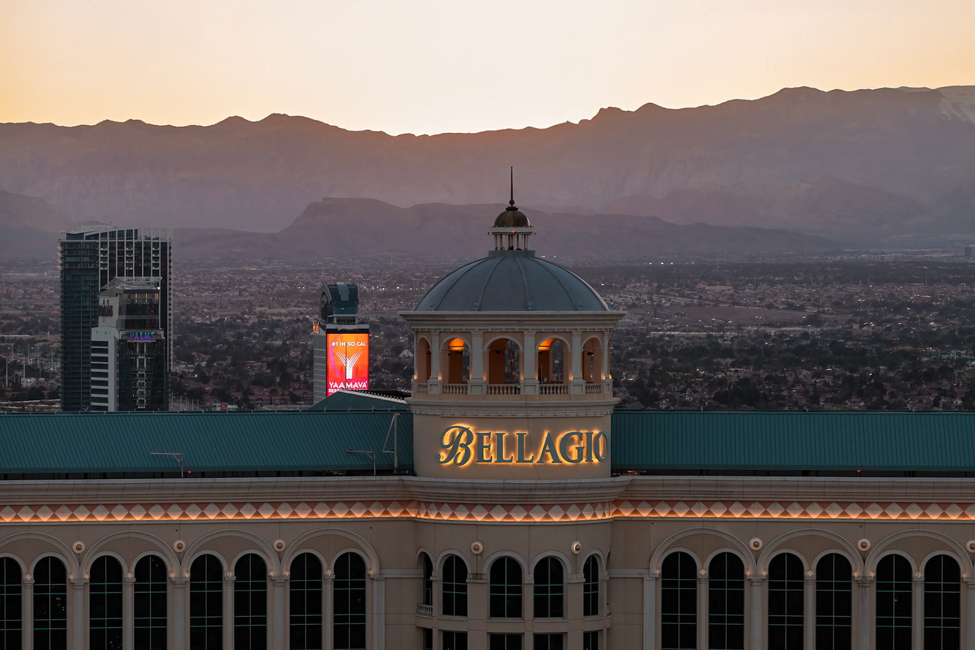 230409_134-Edit Sun setting behind the Bellagio Casino during a fountain show on the strip in Las Vegas, Nevada