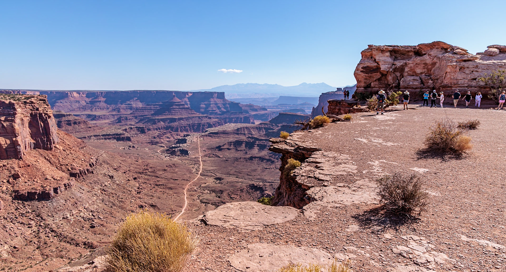 240928_023 Tourists walking on a butte along the Shafer Canyon Overlook at the Island in the Sky area of Canyonlands National Park, Utah, USA