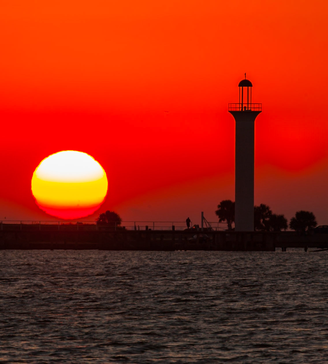 140924_005 Sunrise over the Mississippi Sound turns the sky red light behind the old Broadwater lighthouse in Biloxi, Mississippi