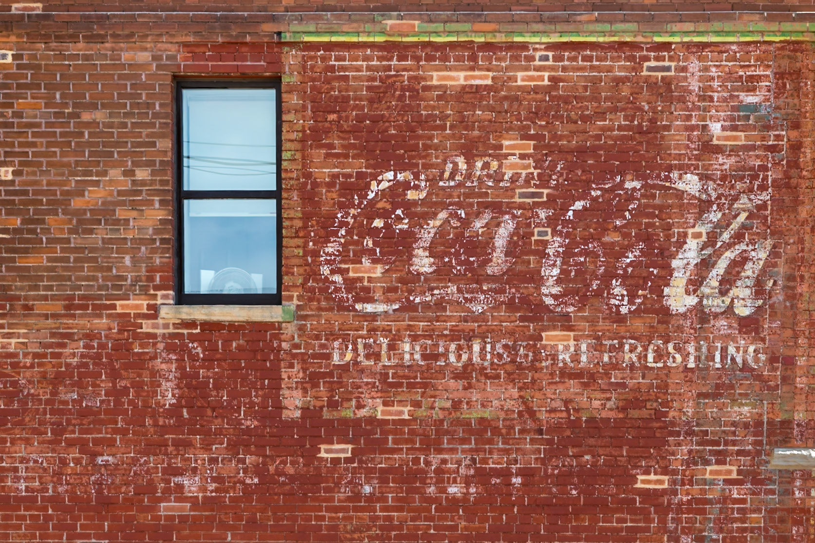 180808_085 Weathered and faded Coca-Cola advertising sign painted on a brick wall of a historic building in downtown Cheyenne, Wyoming