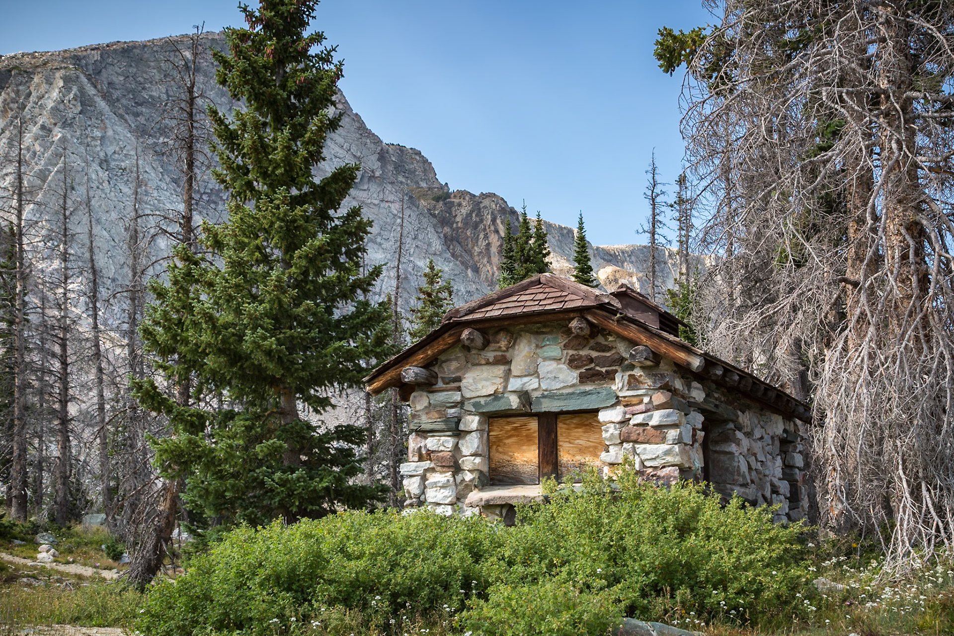 180811_296 Old boarded up stone cabin nestled between the pine trees near Mirror Lake and Lake Marie in the Snowy Range area of Medicine Bow National Forest in Wyoming