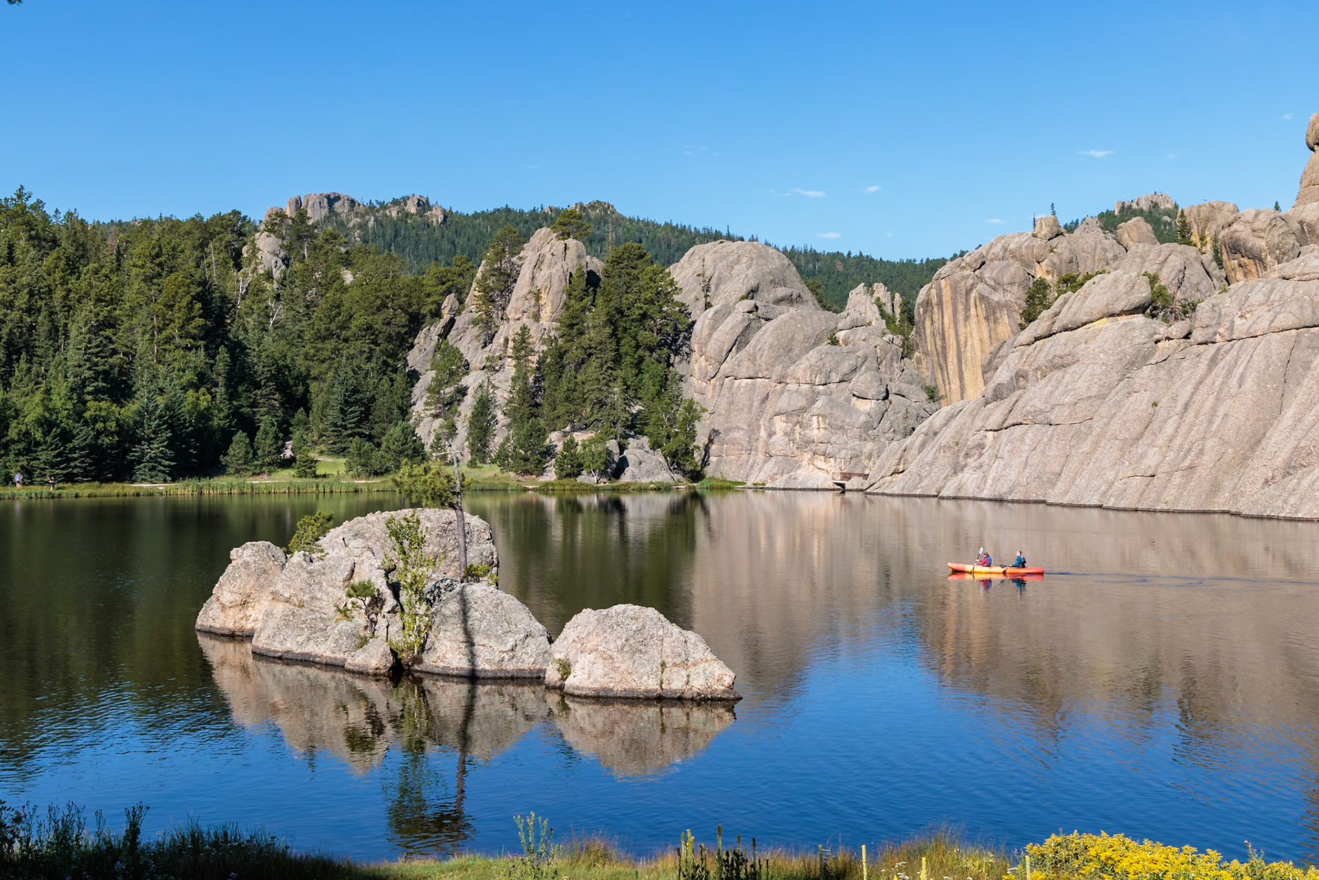 240817_054 Kayakers in the calm waters of Sylvan Lake in Custer State Park, South Dakota, USA