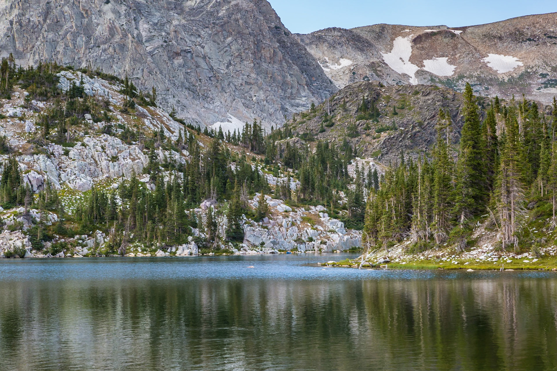 180811_249 Evergreen trees along the shoreline of Mirror Lake at the base of the mountains in the Snowy Range area of the Medicine Bow National Forest in Wyoming
