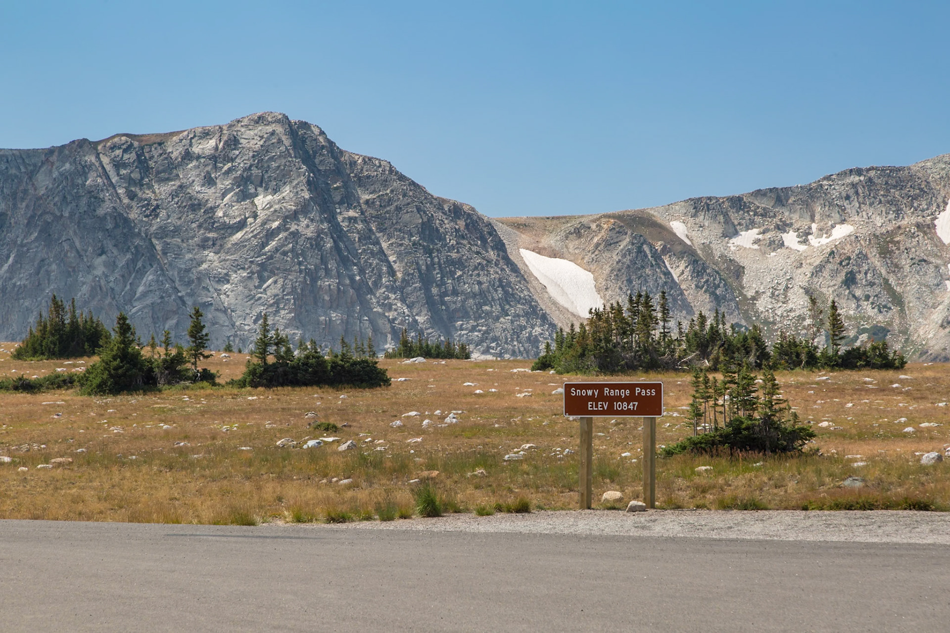 180811_199 Sign in front of mountain with remaining snow in August at the Snowy Range Pass in the Medicine Bow National Forest in Wyoming