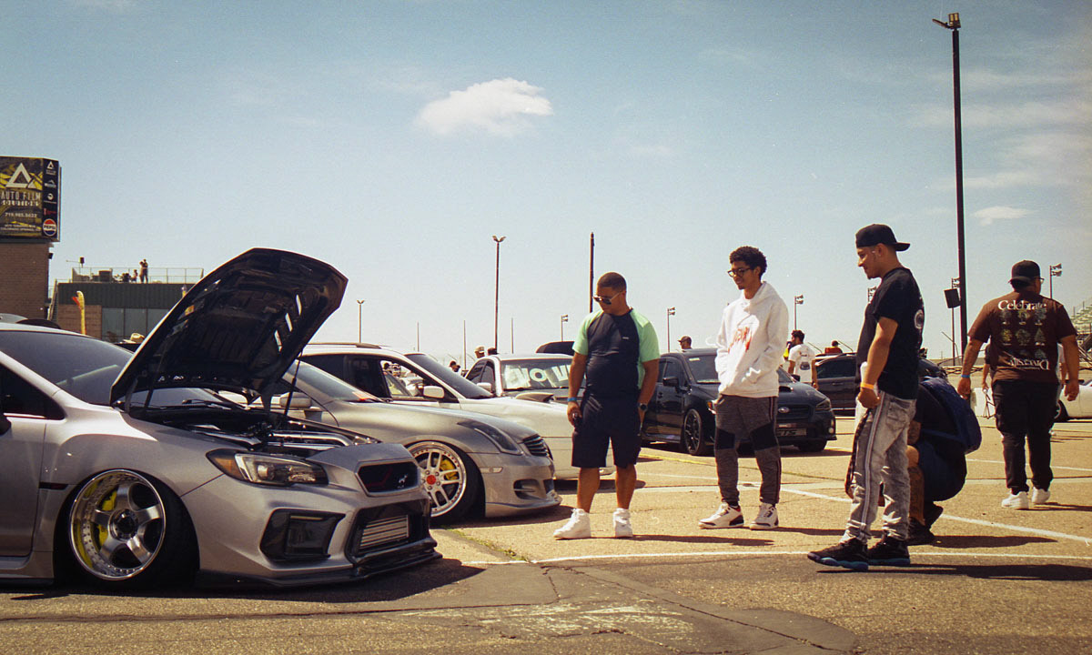 A group of guys admires a car at the 2024 SLUSH Motorsports Festival