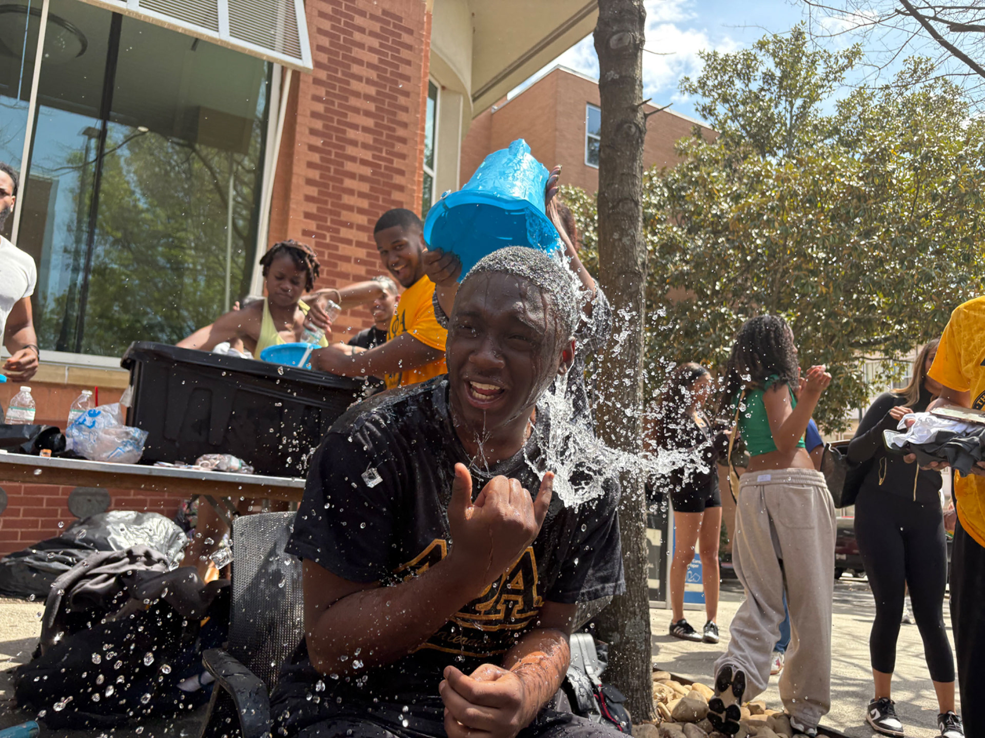 ICE COLD Chris tries to remain sitting in the chair and hold the 'phi' as he is soaked with a huge bucket of ice water on Brown Street. (Photo/Noah Cathey)