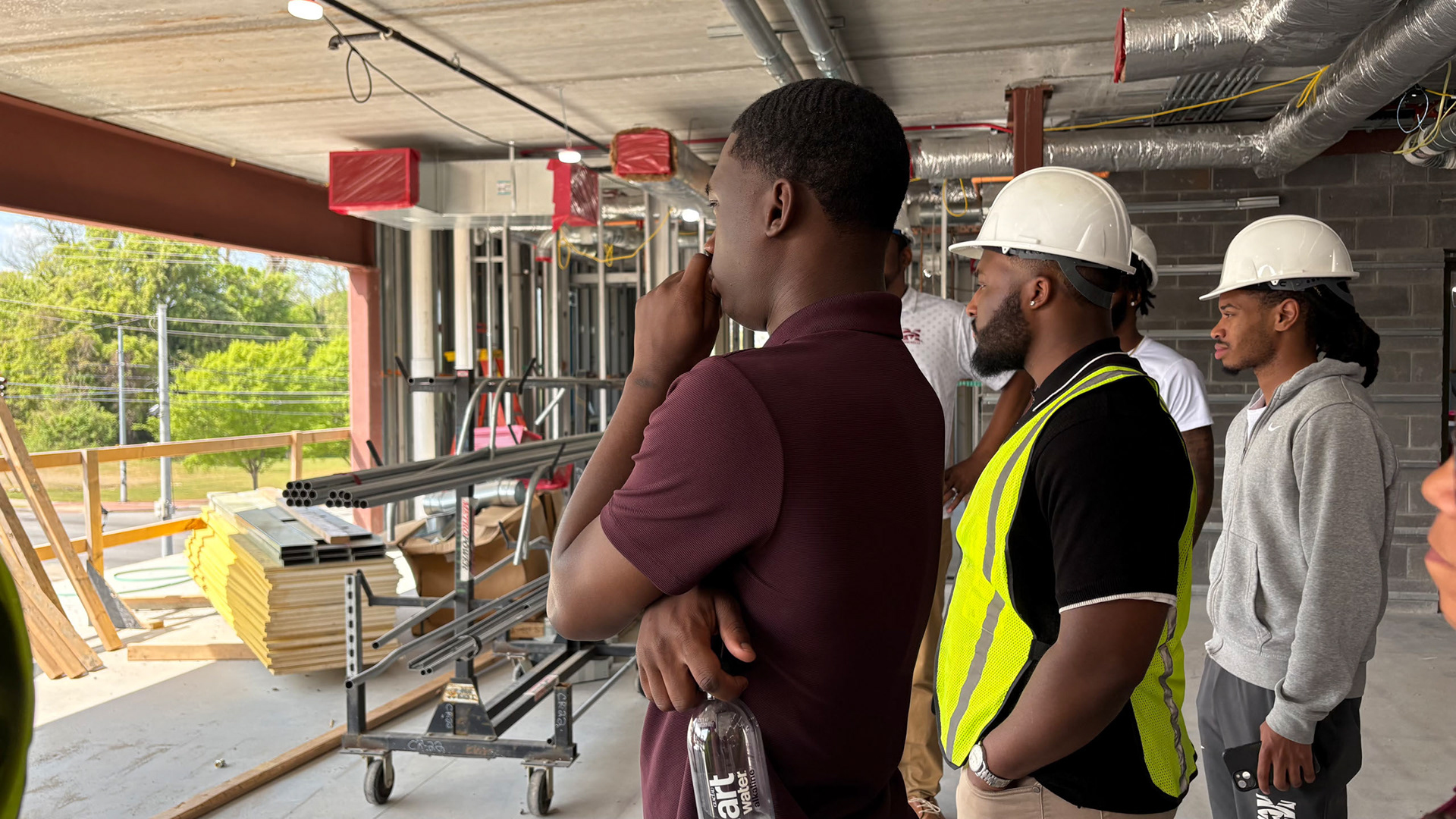 LOOKING INTO THE FUTURE Preparing to ask a pressing student question to the general contractors, Chris looks at what will be a glass wall peering over the heartbeat of campus. (Photo/Noah Cathey)