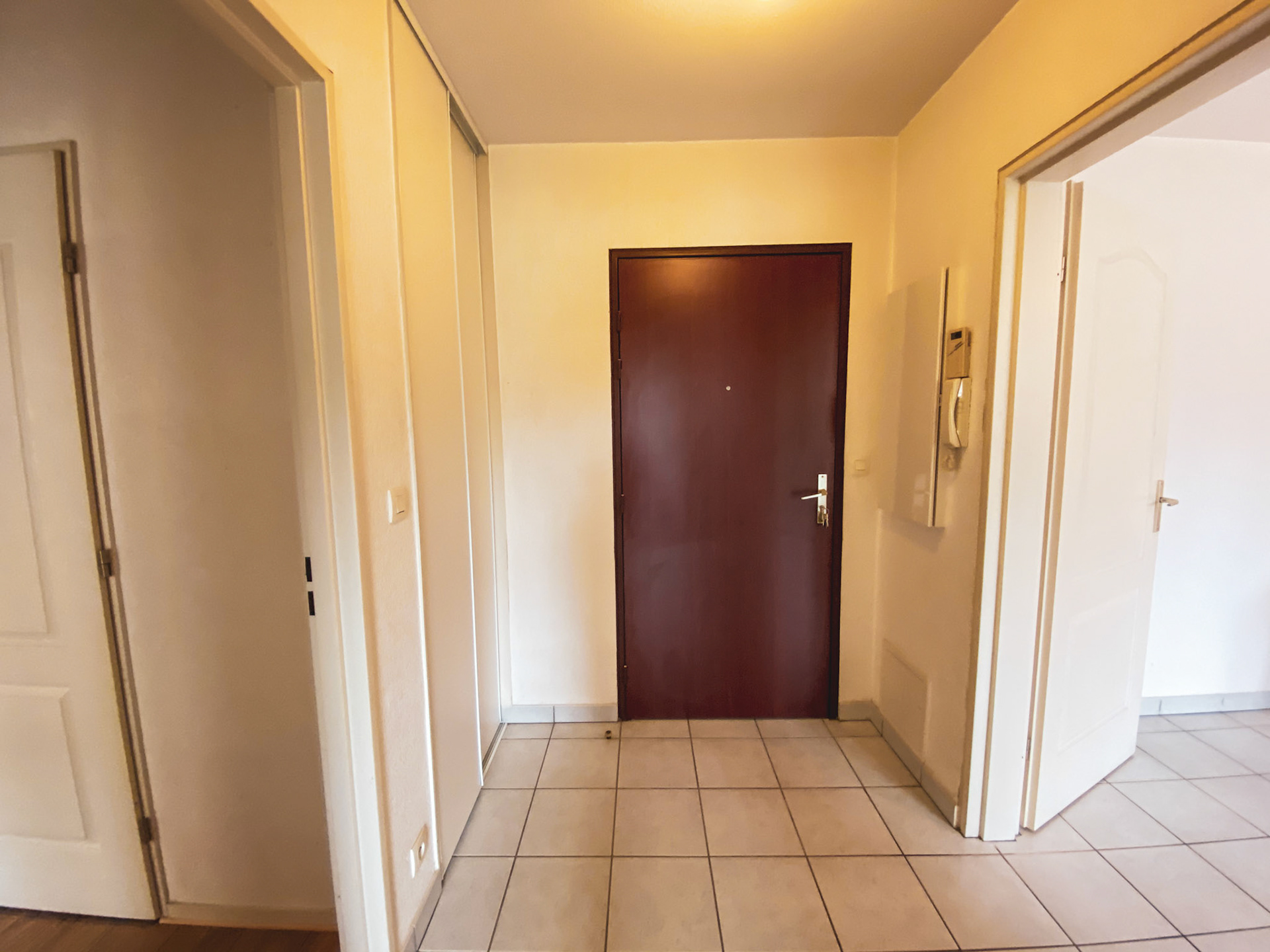 Vue de la porte d'entrée et du couloir de l'intérieur de l'appartement