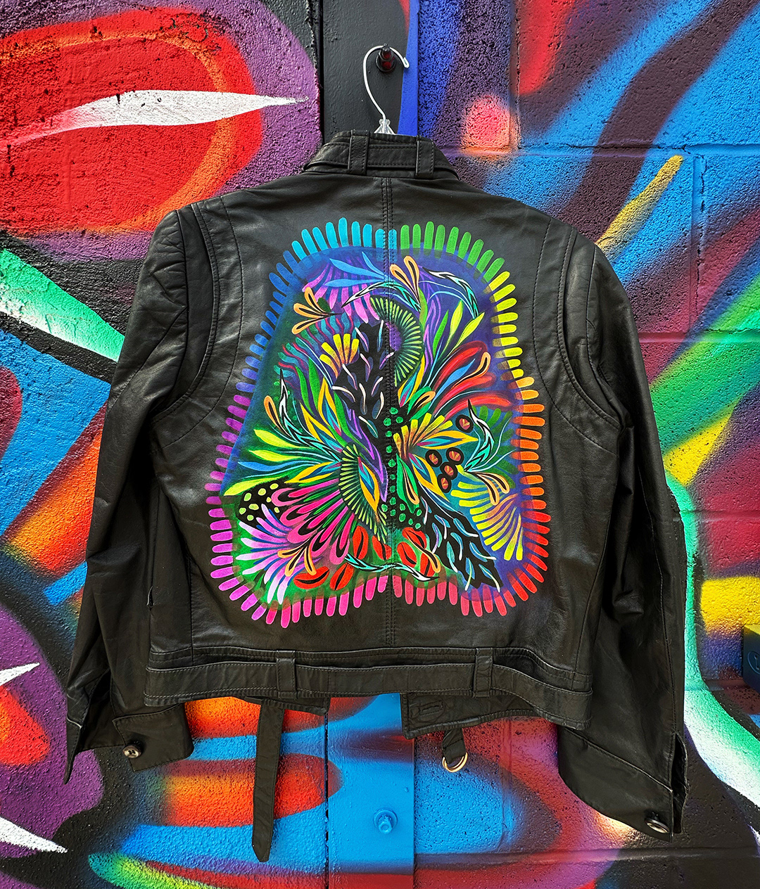 black leather jacket with custom painted colorful abstract botanical design with rainbow border