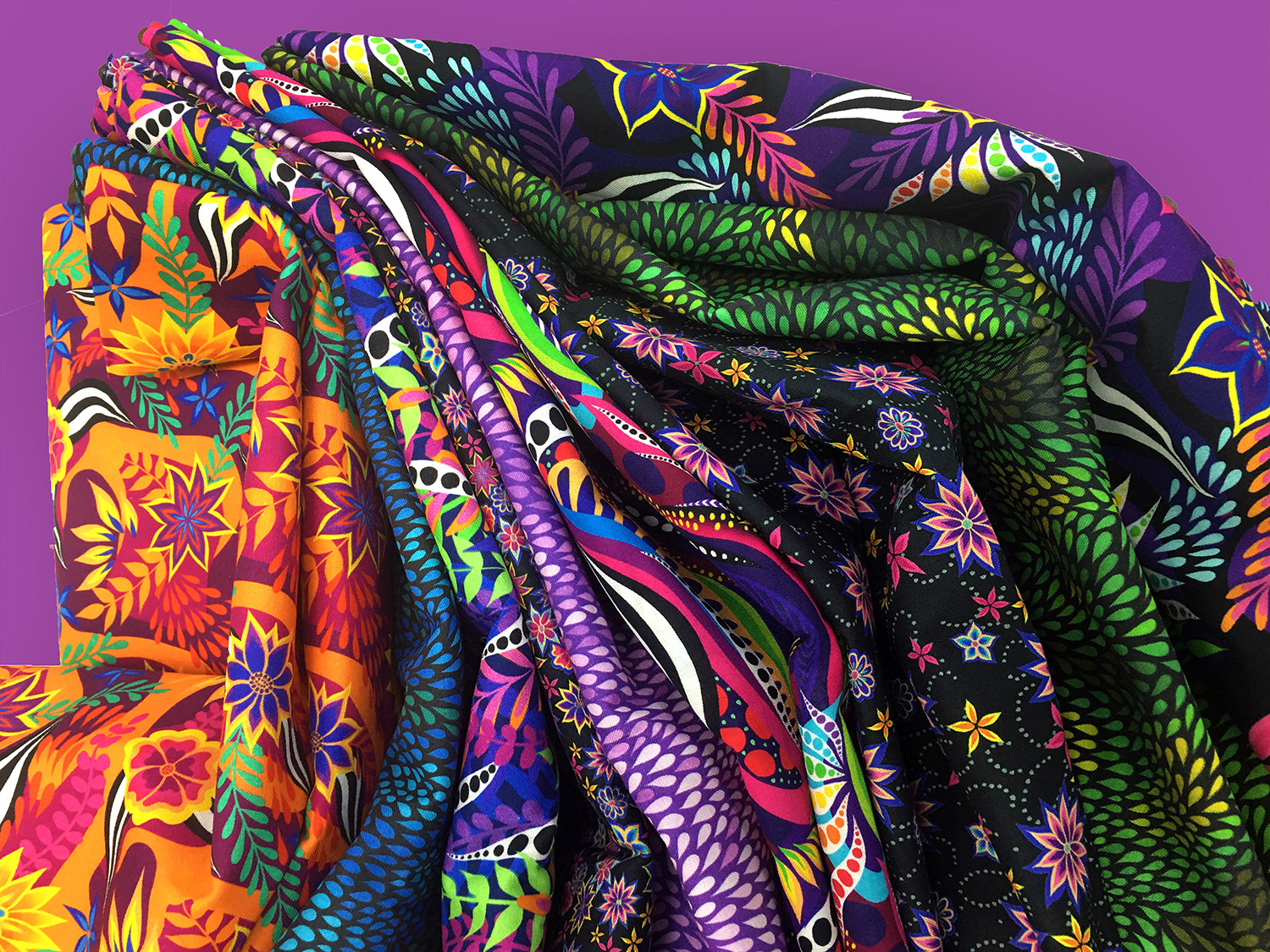 stack of colorful abstract and botanical printed quilt fabrics