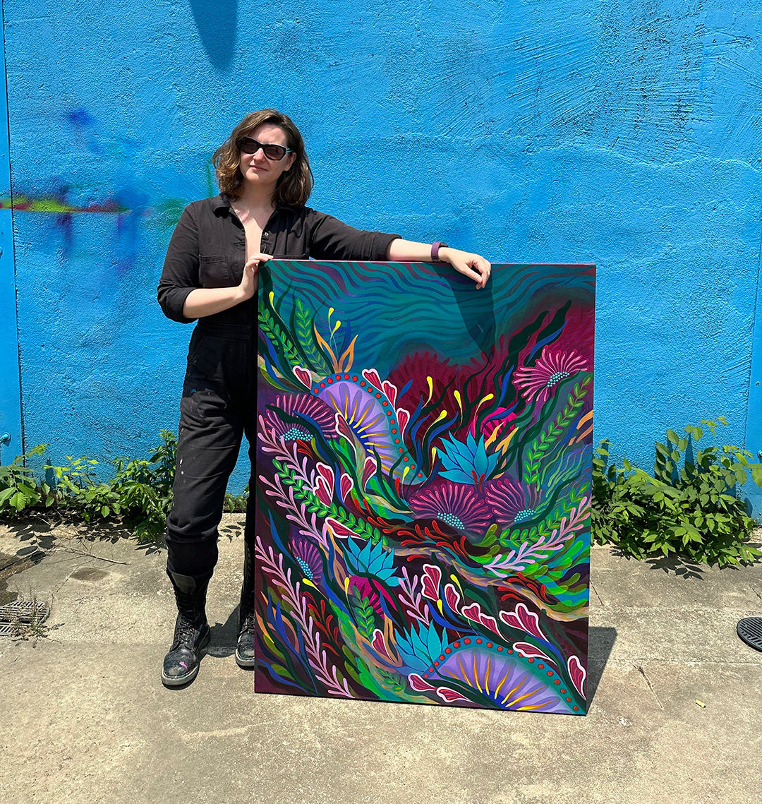 me standing in front of blue wall posing with large coral reef theme artwork on canvas