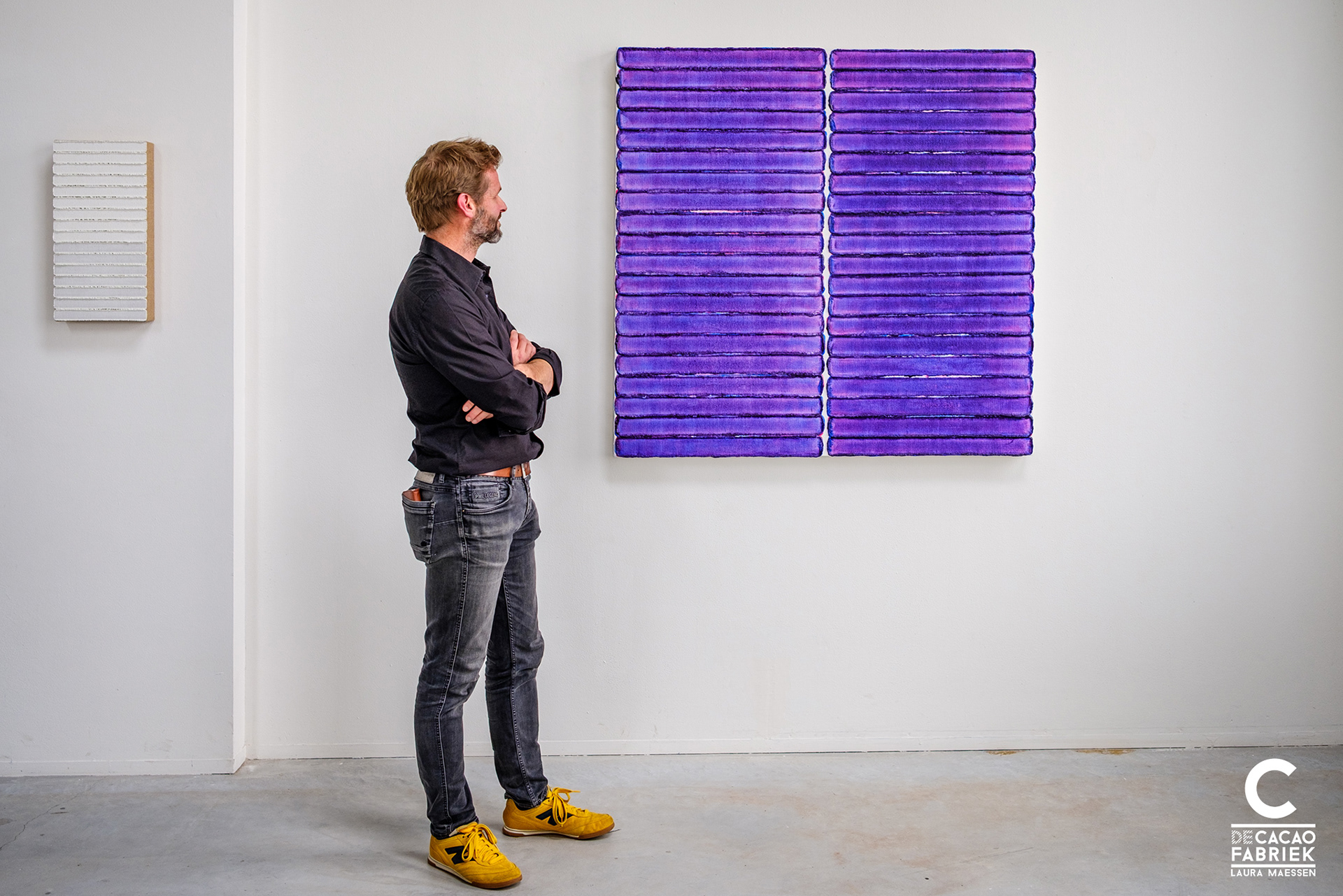 Maurice van Venrooij standing in front of his abstract painting 240903 in transparant purple with tactile edges and multi-layered in color.