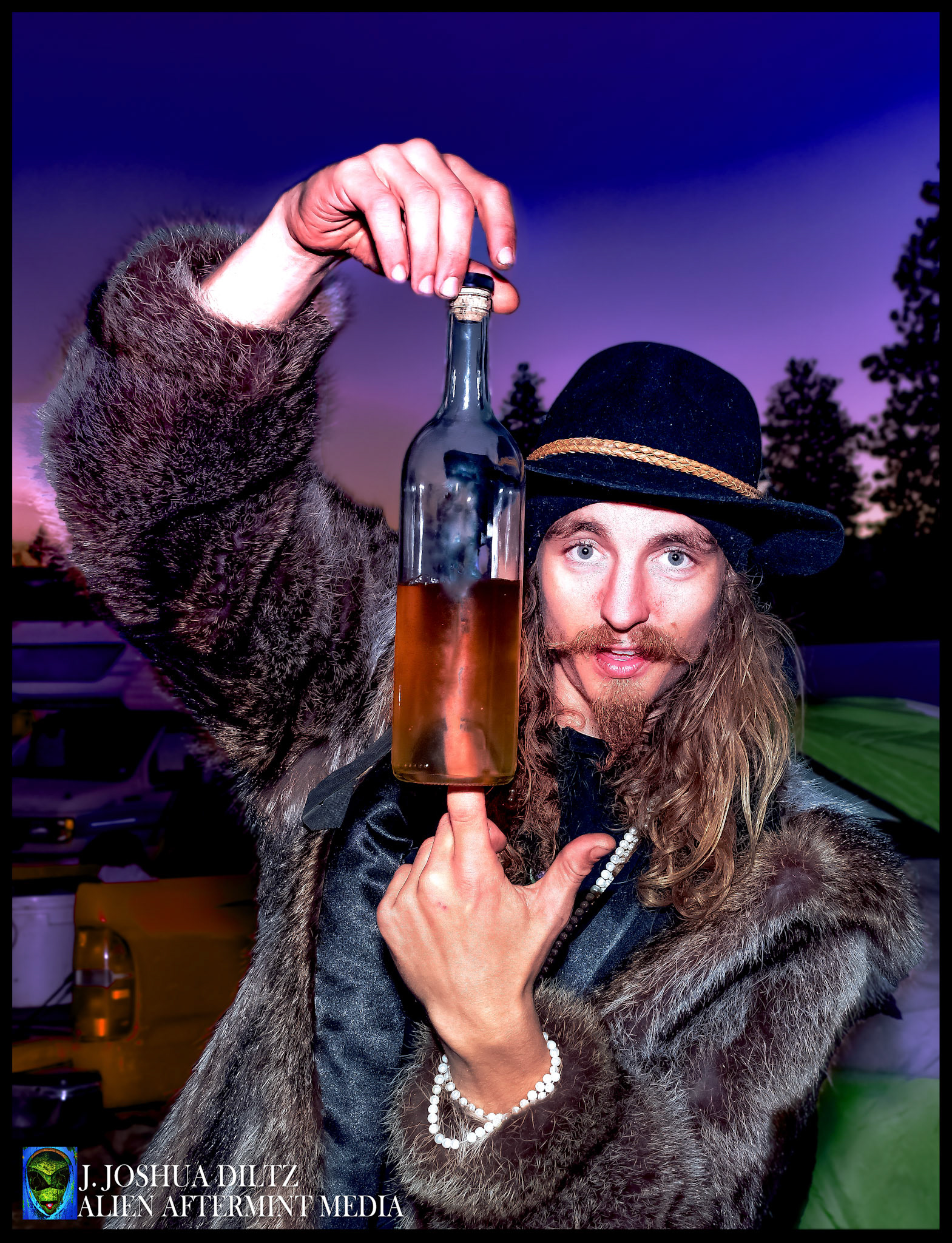 Runes of Neptune Cypher/vocalist Torin Frost poses with a jug of old fashion Moonshine at the Runes of Neptune campsite at Okanogan Family Barter Faire 2018.  [Tanaskit, Washington October 2018]  Photo by J. Joshua Diltz, Alien Aftermint