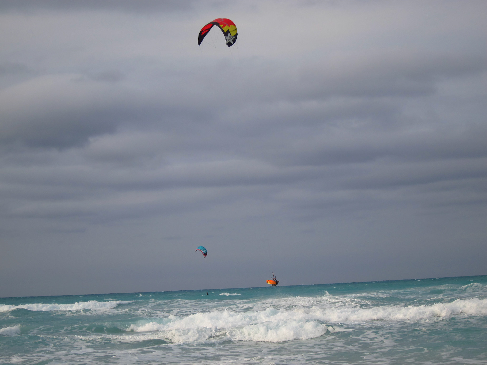 Kite surfers out in the ocean waves