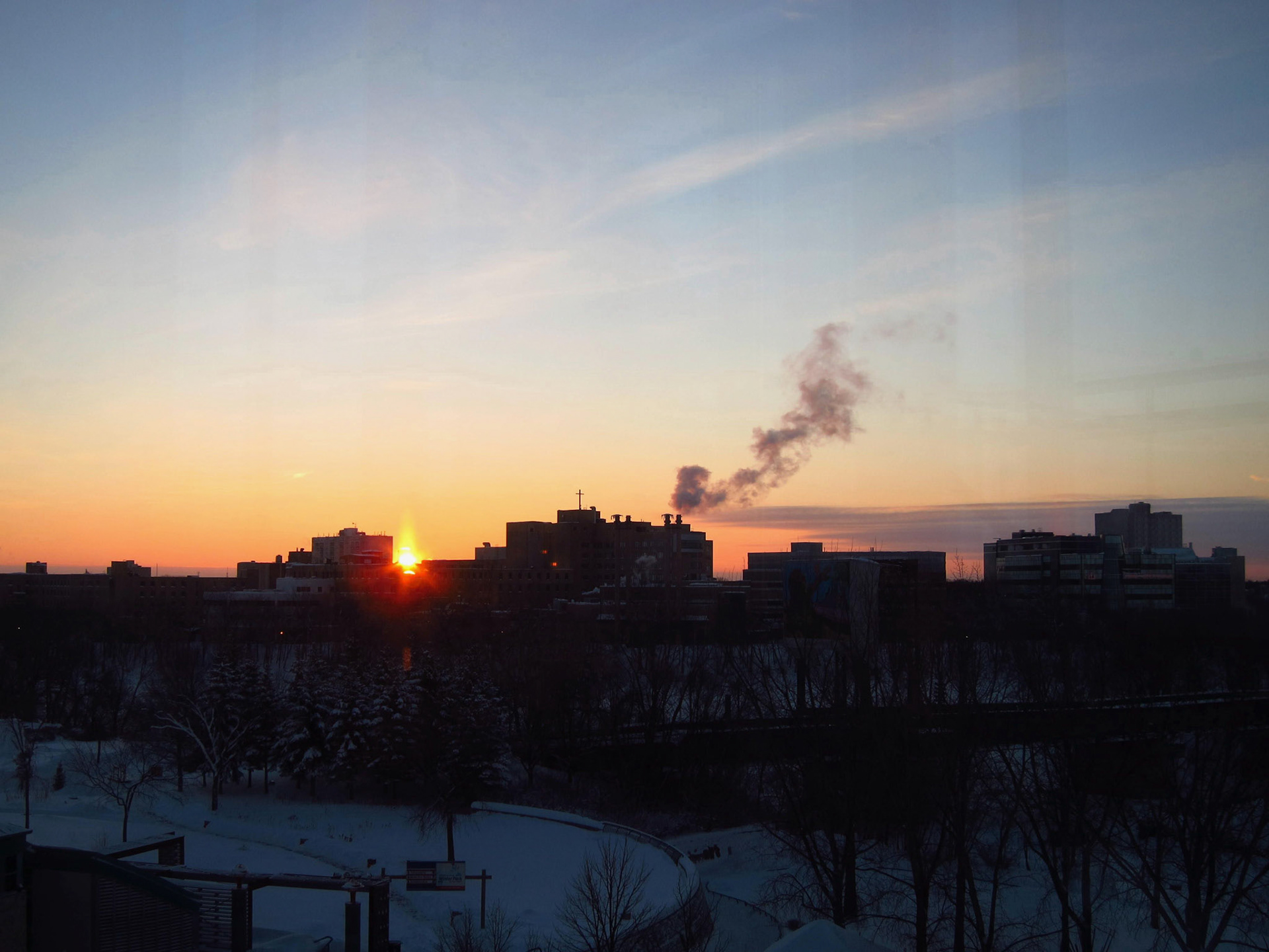 The sun rises over the Forks of the Red and Assiniboine Rivers in Winnipeg