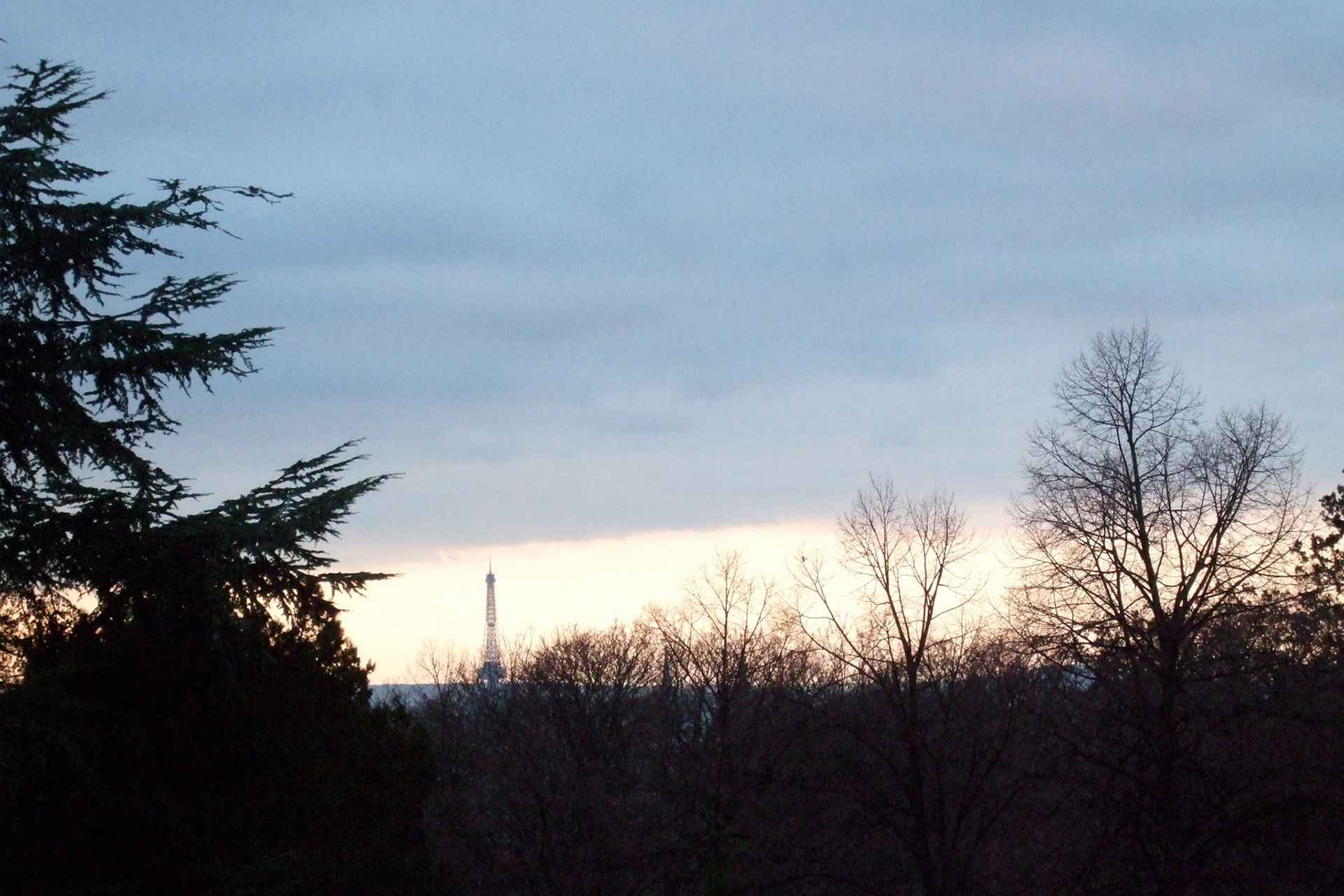 The sun sets early in the winter in France. You can see the Eiffel Tower from Pere Lachaise cemetery