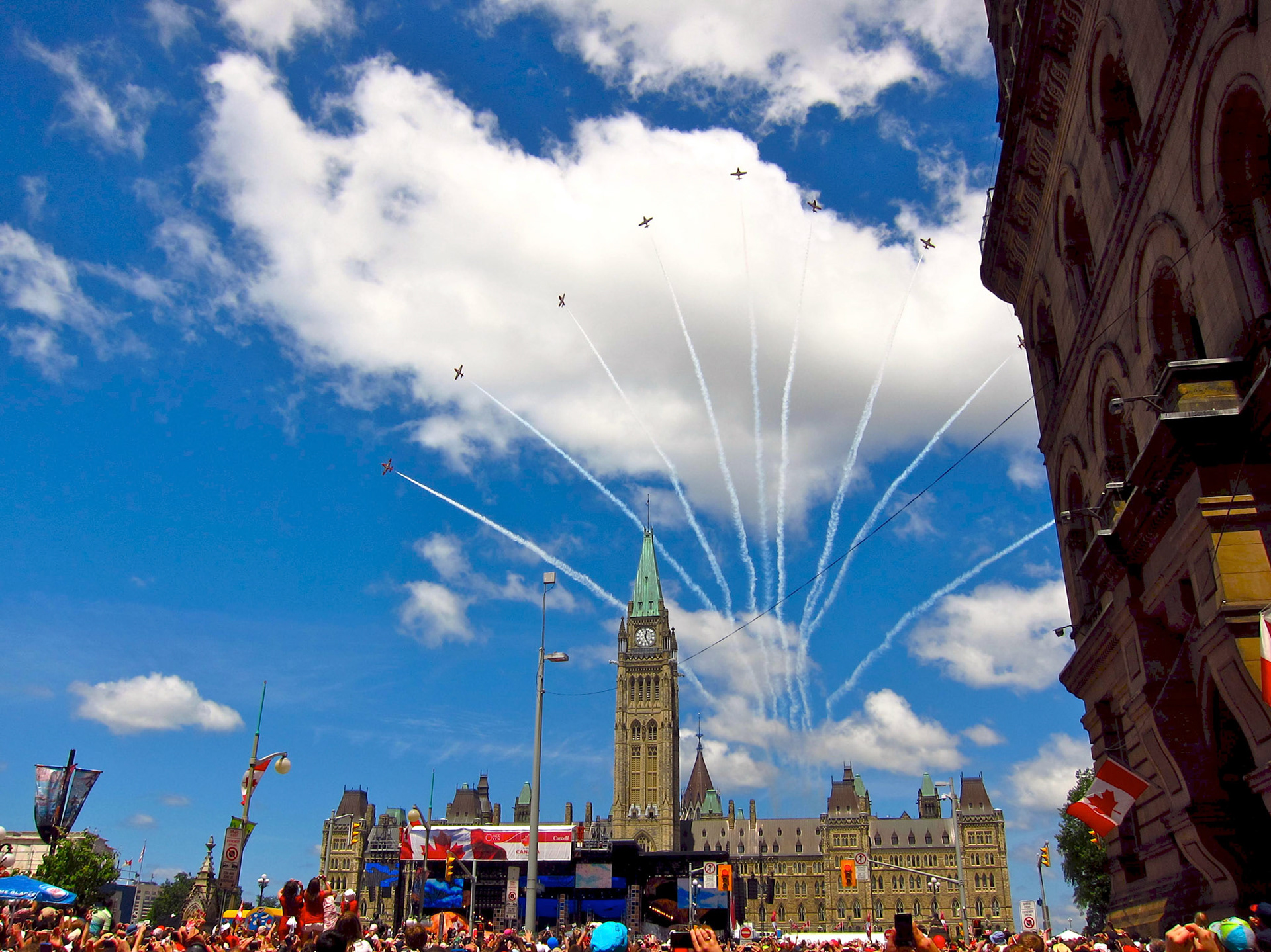 The Canada Day crowd cheers as the Snowbirds perform over Parliament Hill