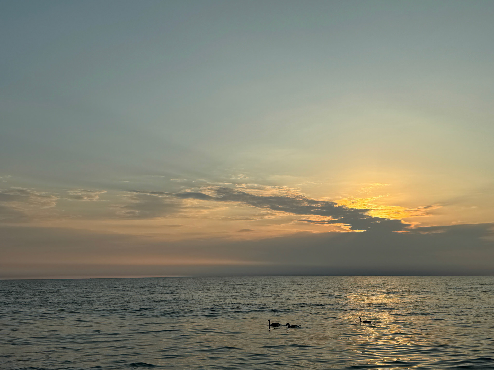 The sun begins to rise over Lake Michigan at North Avenue Beach