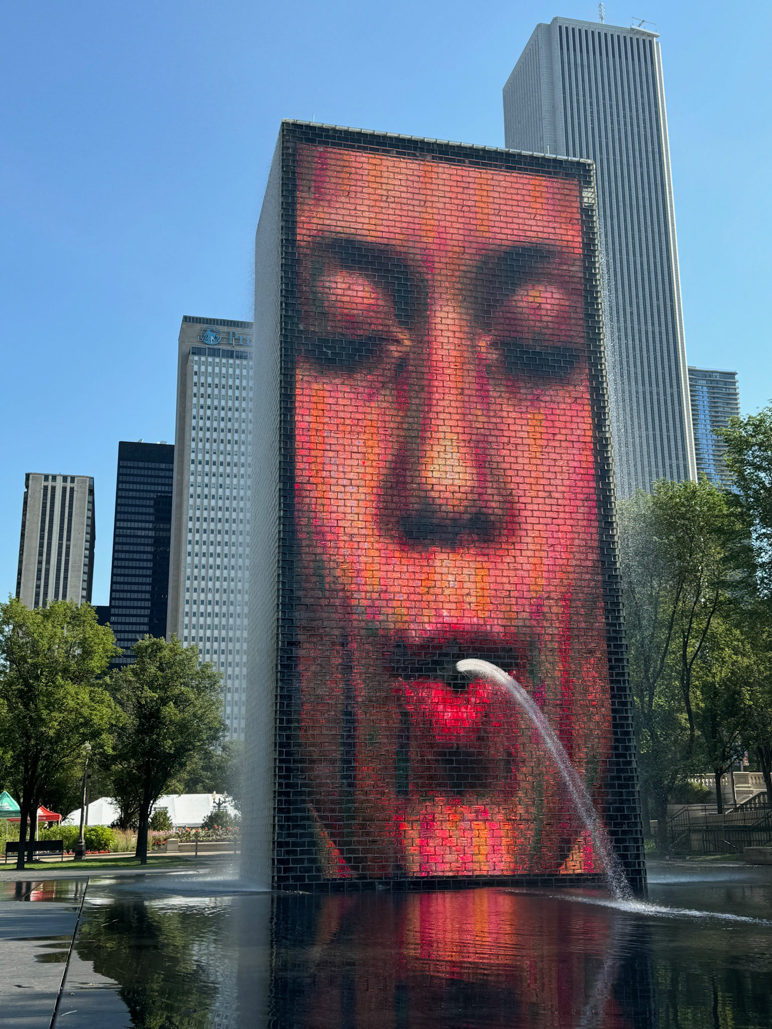 The cheeky Crown Fountain in Millenium Park. It displays animated videos of people's faces, with water occasionally spouting from their mouths