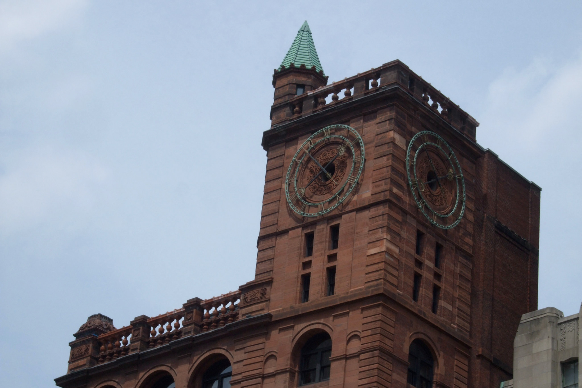 A clock tower on a building facing Place d'Armes