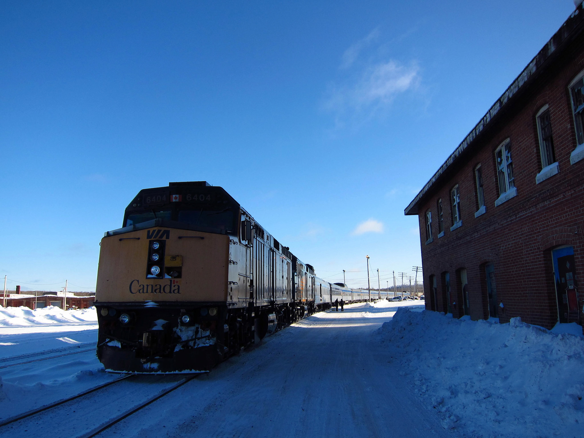 The Canadian stopped in Hornepayne, Ontario - with an abandoned railway building beside