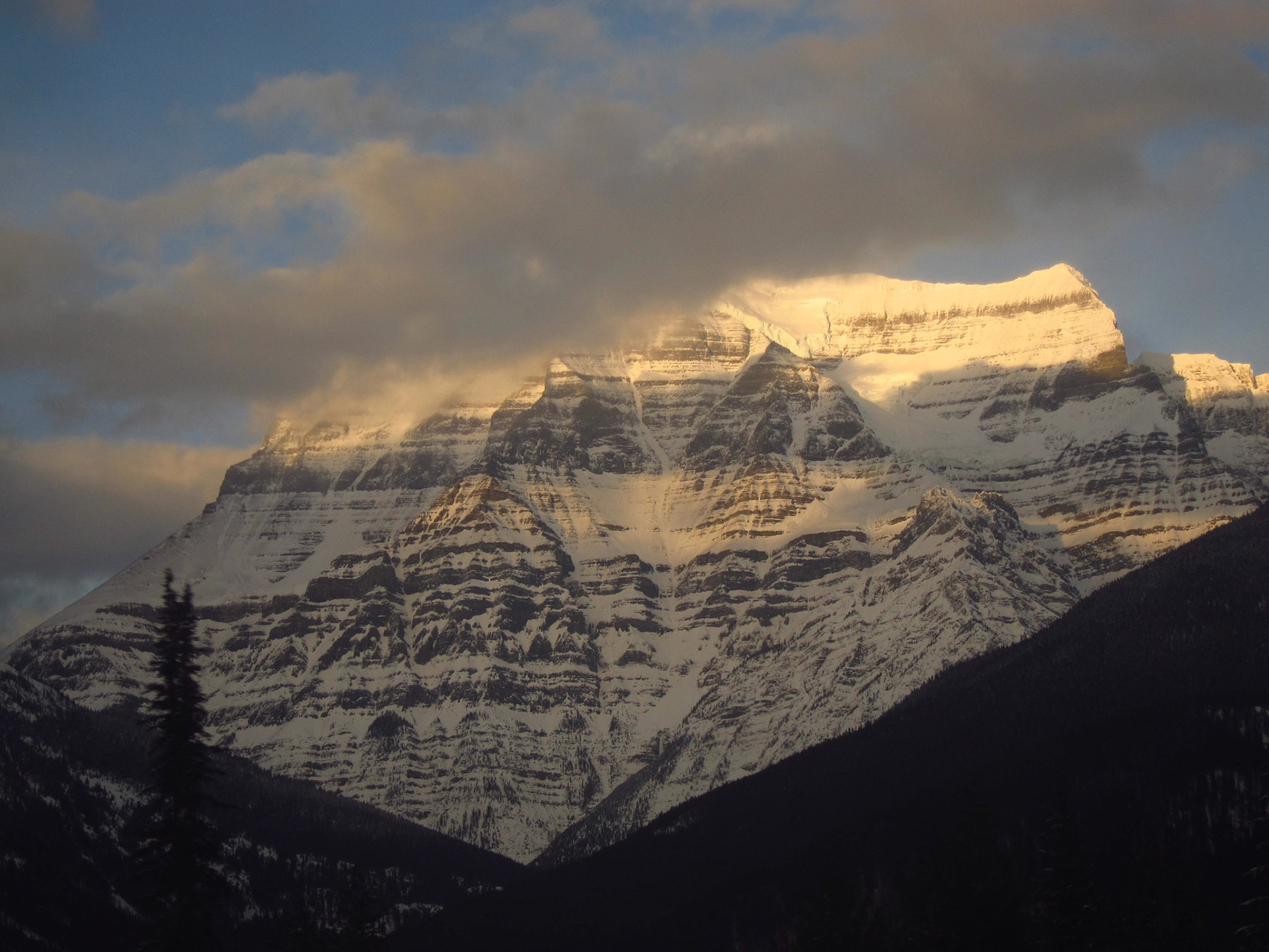 The sun and clouds against Mount Robson create a very dramatic view