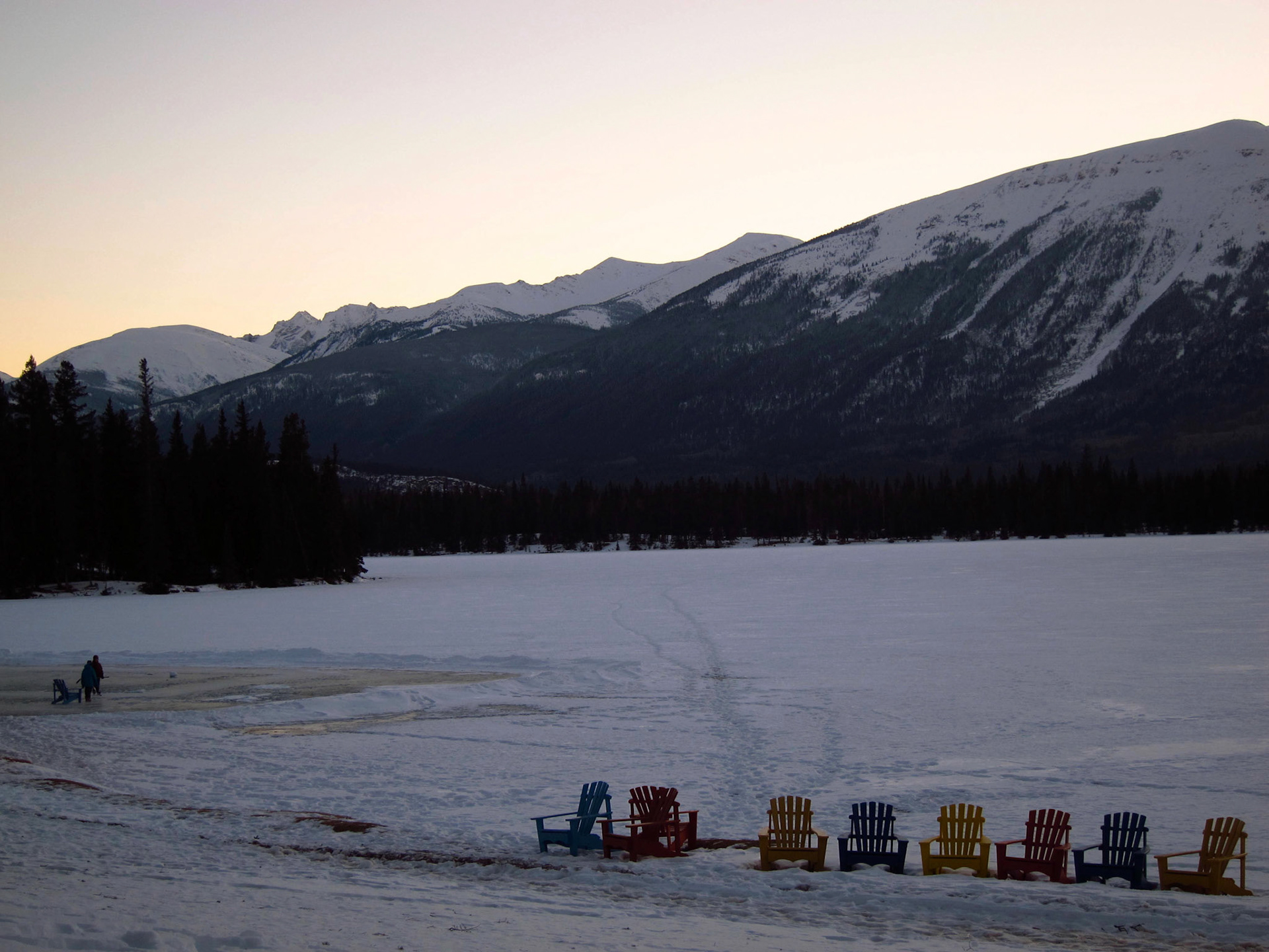 The winter scene from Jasper Park Lodge: skaters on Lac Beauvert with the mountains in the distance