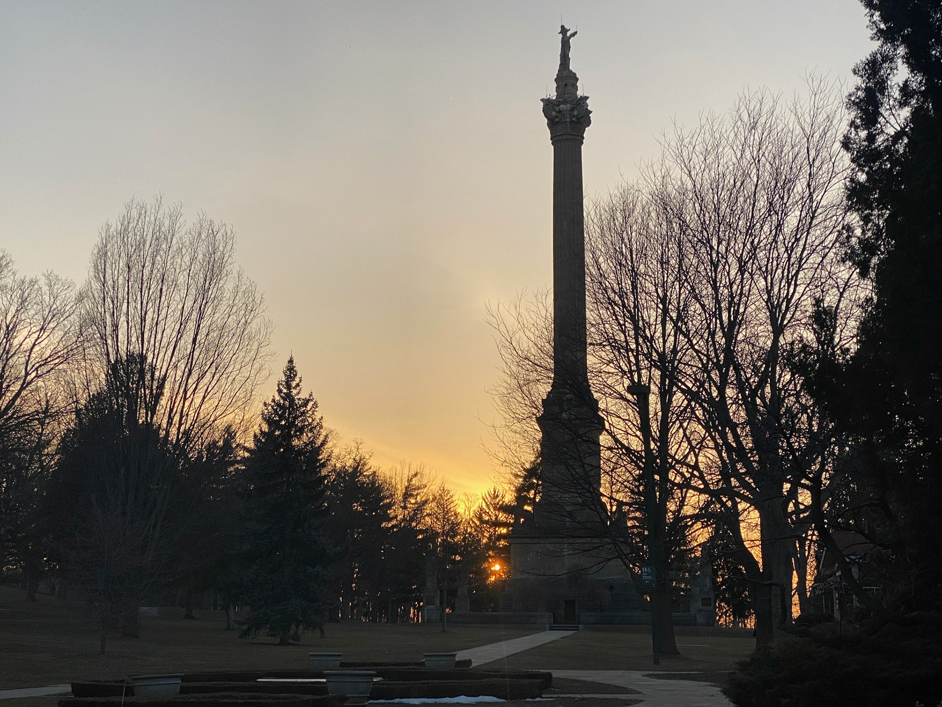 The sun sets behind the Brock Monument