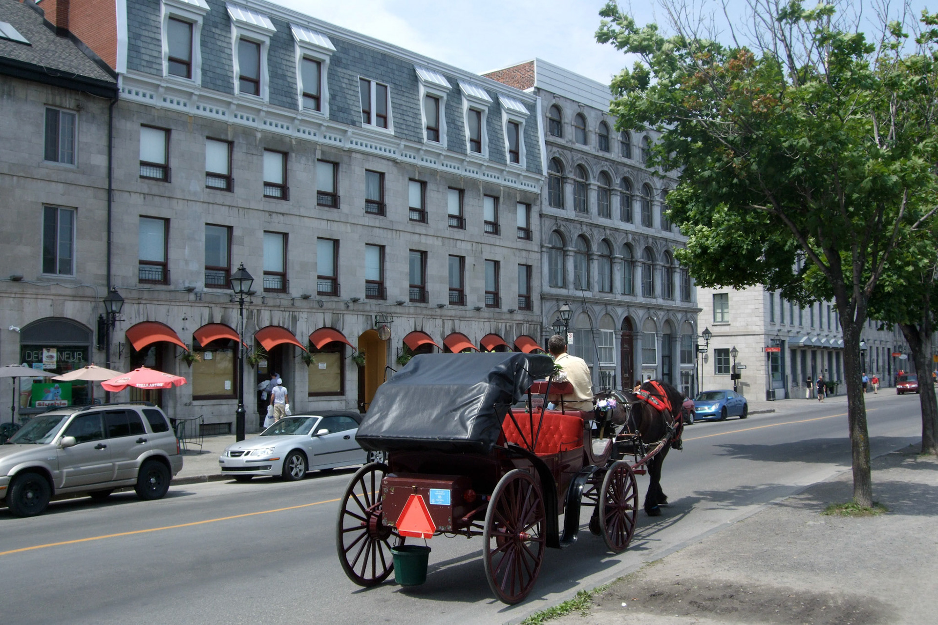 A horse-drawn carriage trots through the Old Port of Montreal