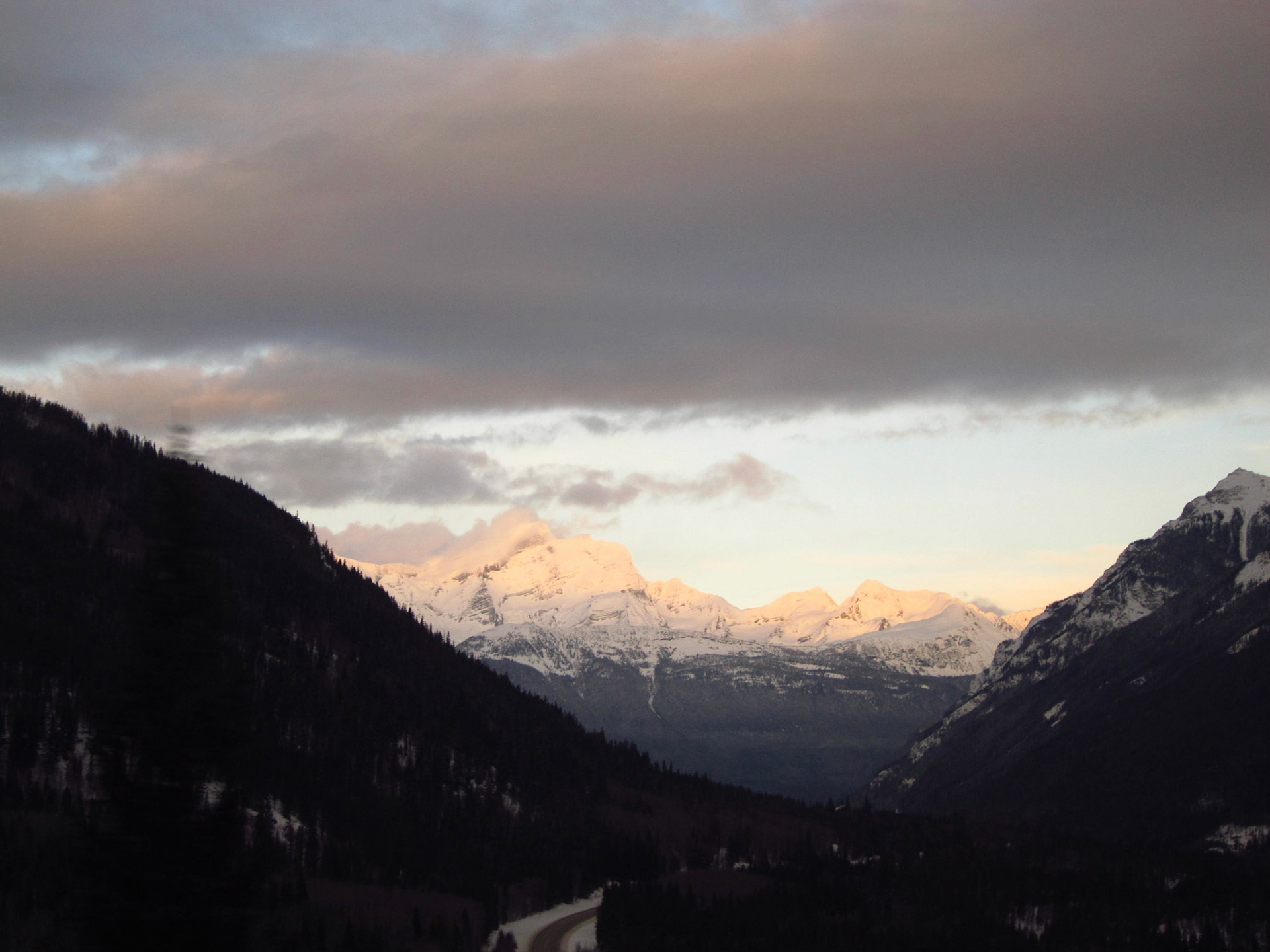 Just before Mount Robson passes beyond our view, the peak barely escapes cloud cover