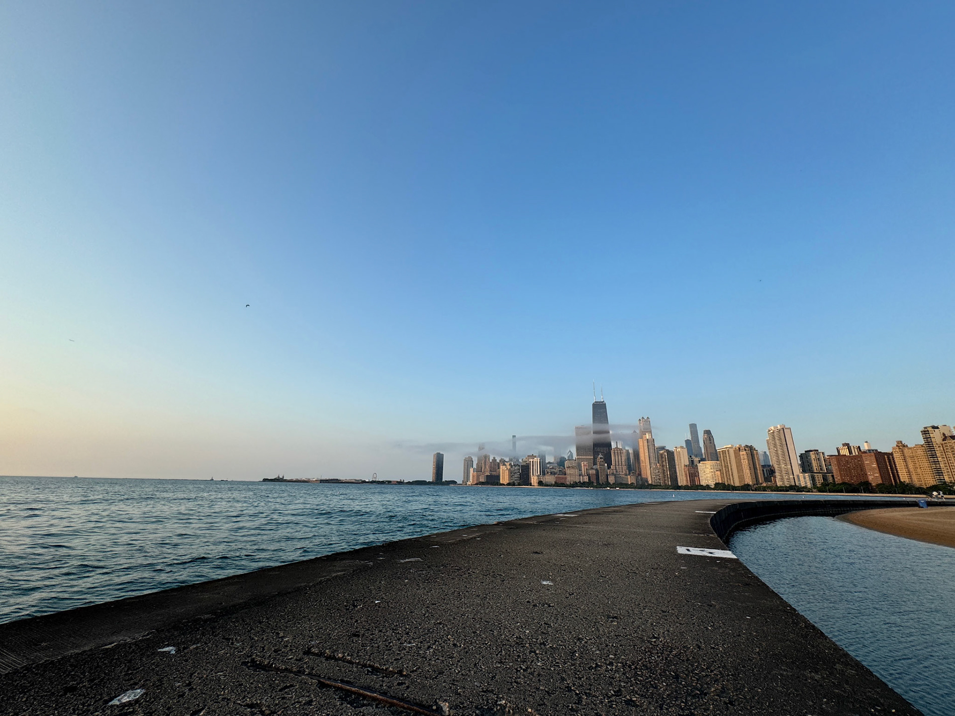 Just as the sun broke through the low clouds, a whift of mist appeared over the bay around Chicago's Gold Coast in front of the skyline